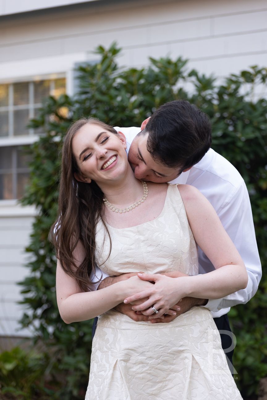 Leah Ramuglia Photography a groom kisses his bride on the neck at home after their Massachusetts wedding