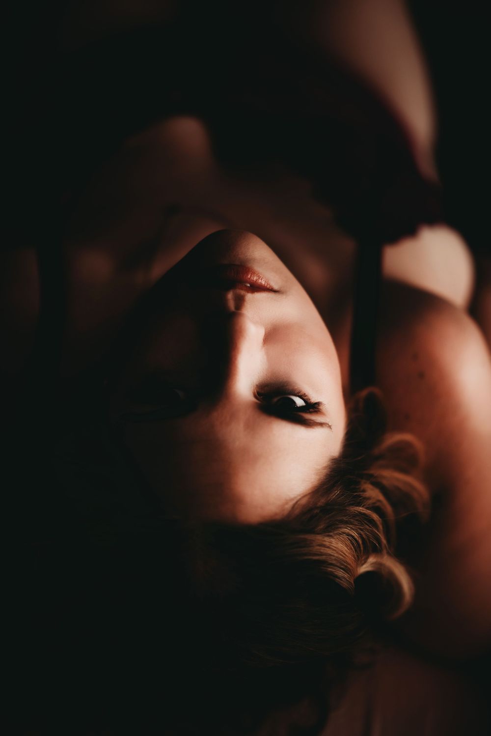 a dark image of a woman looking up