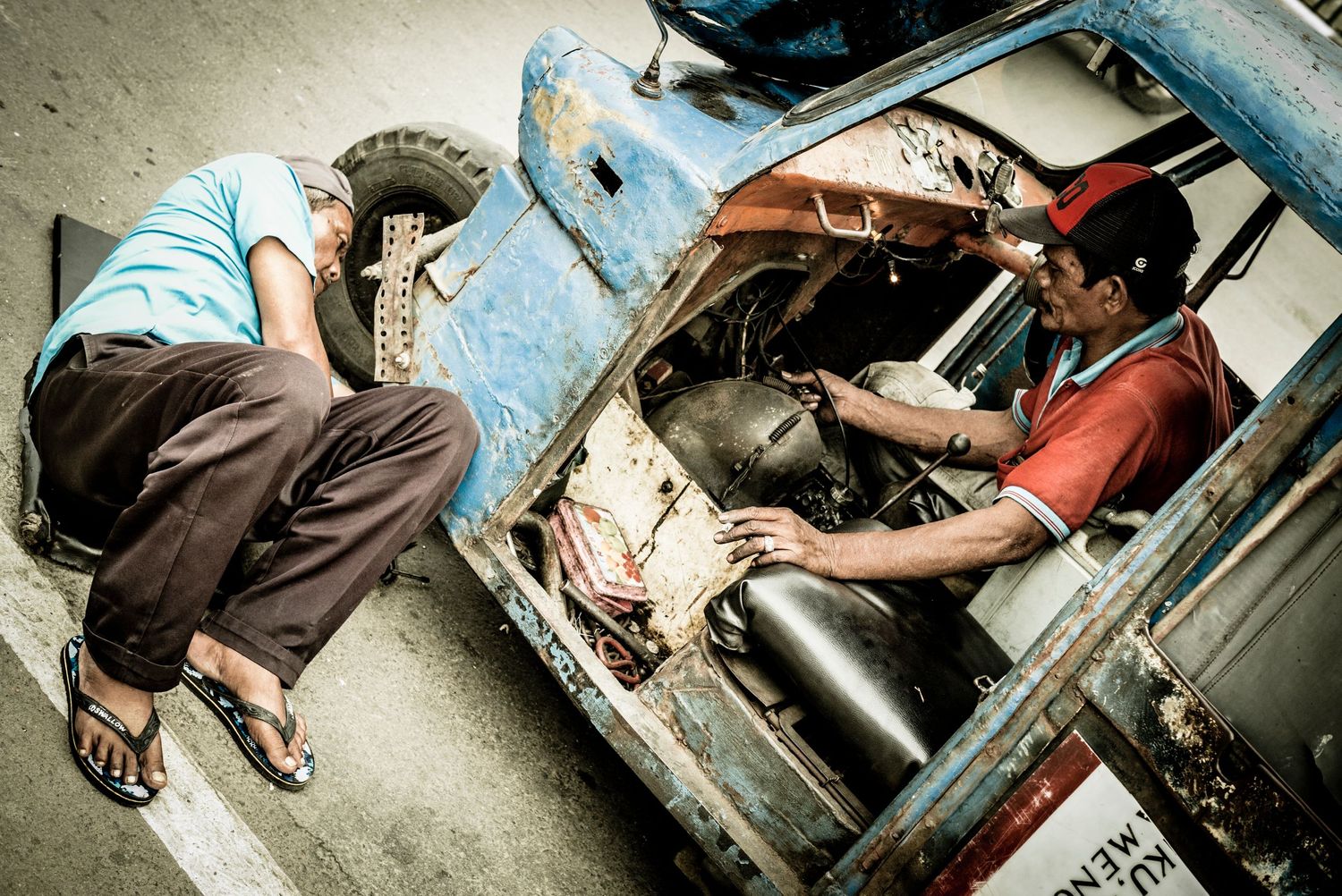 Men working to fix old tuk-tuk in Gloodok district of Jakarta Indonesia
