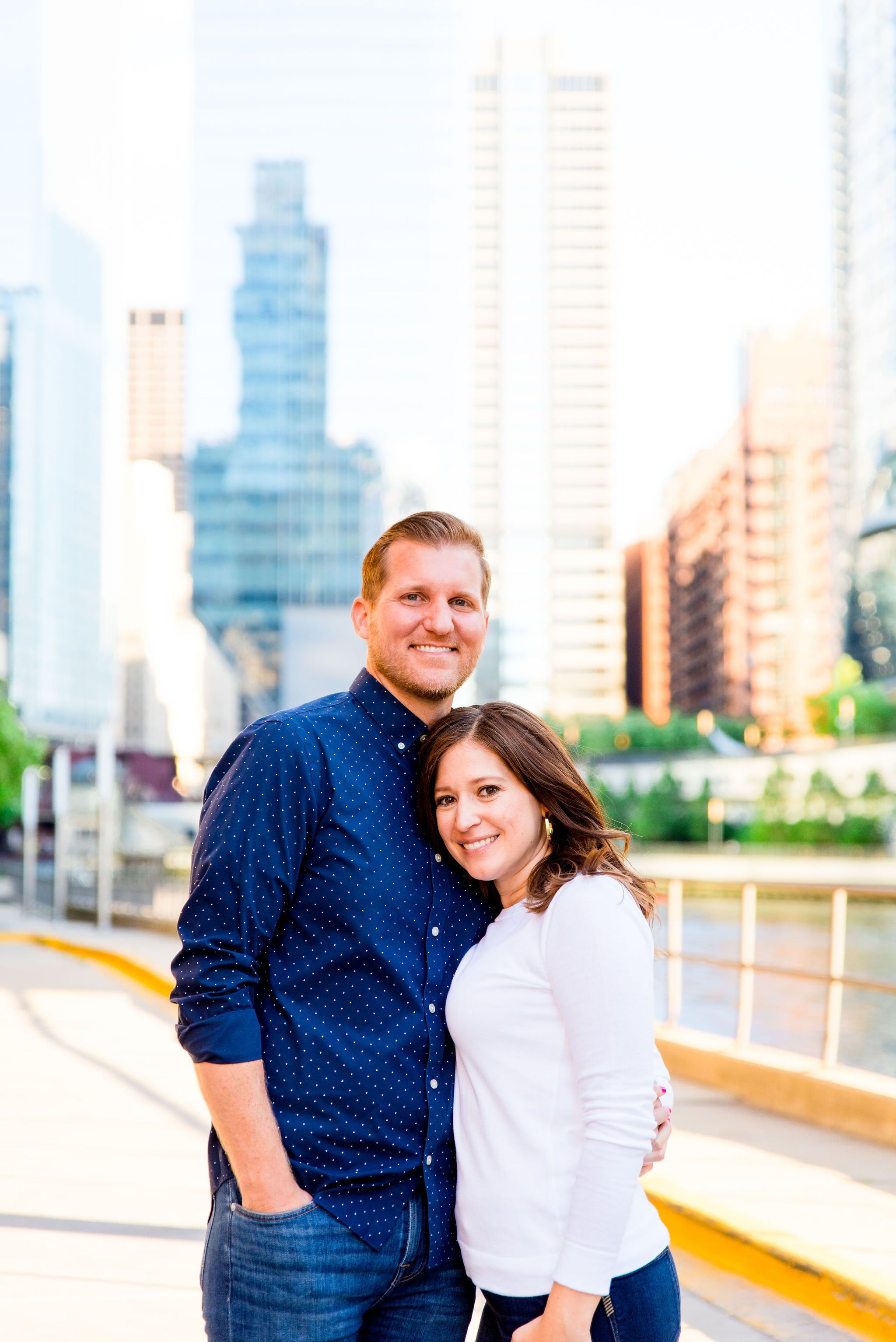 man and woman standing together smiling near River North Kinzie St Bridge engagement pictures