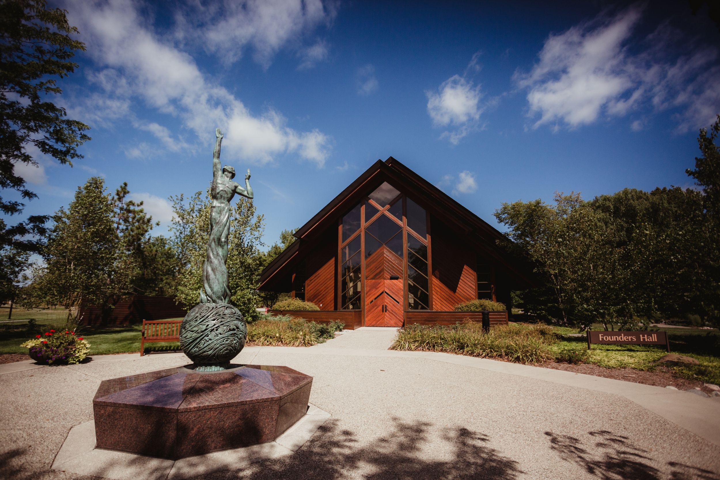 Outside of Founder's Hall at SVSU. Bright blue sky with fluffy clouds behind it.