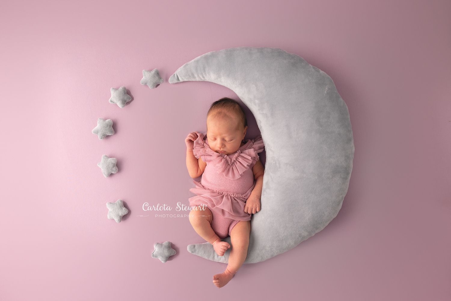 Newborn baby sleeping with a grey moon