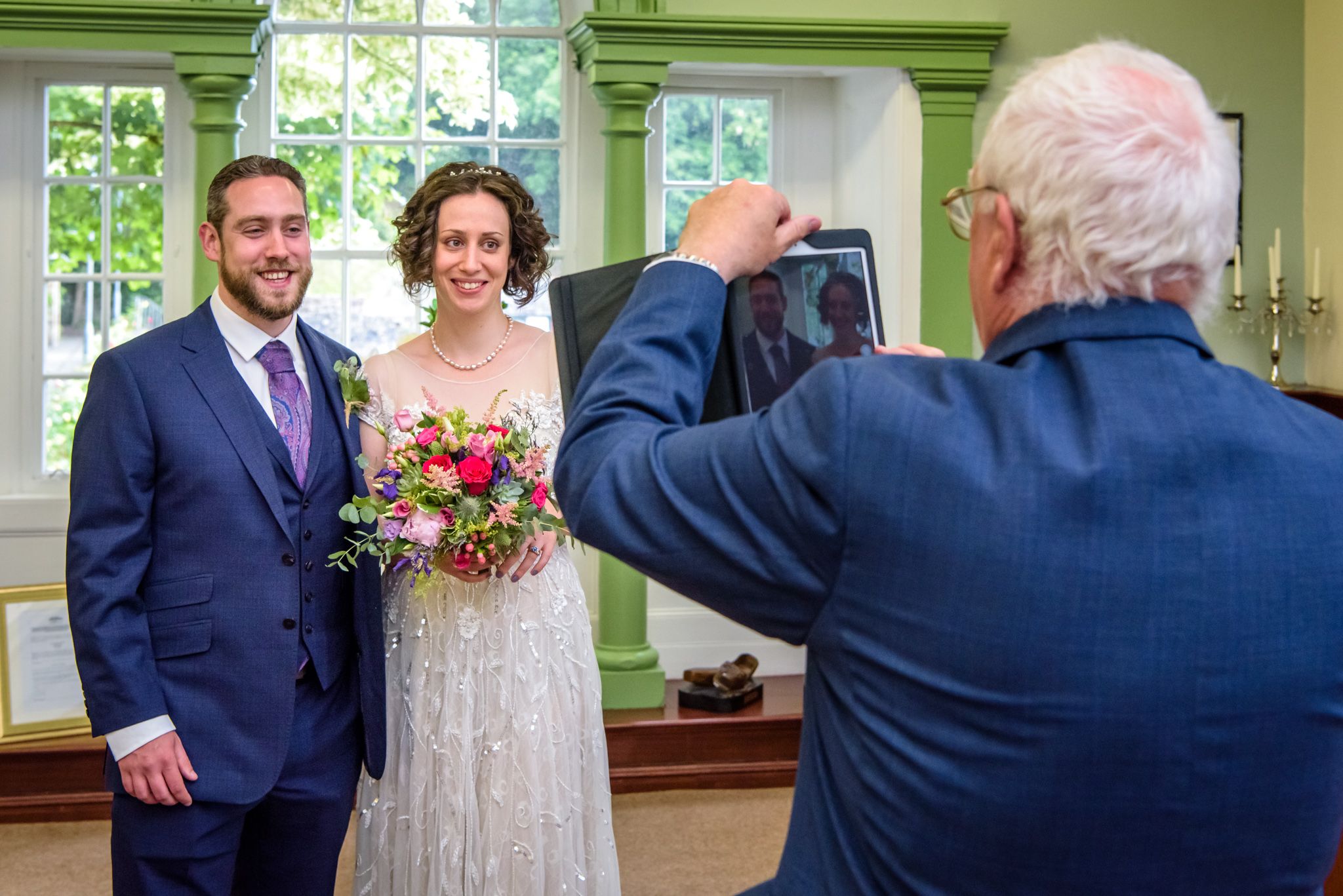 Father of bride taking iPad picture after wedding ceremony