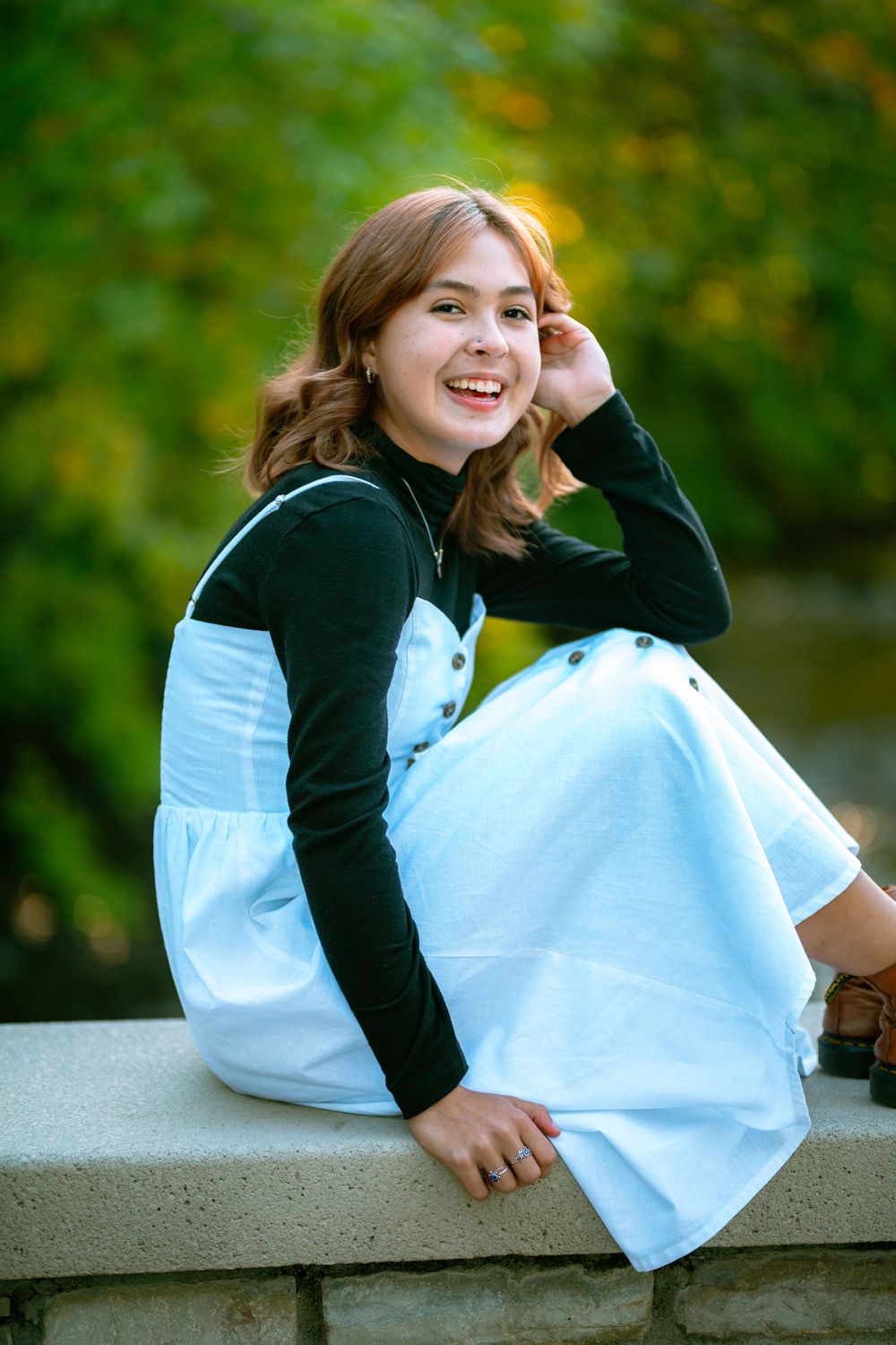 senior girl at golden hour sitting on a bridge
