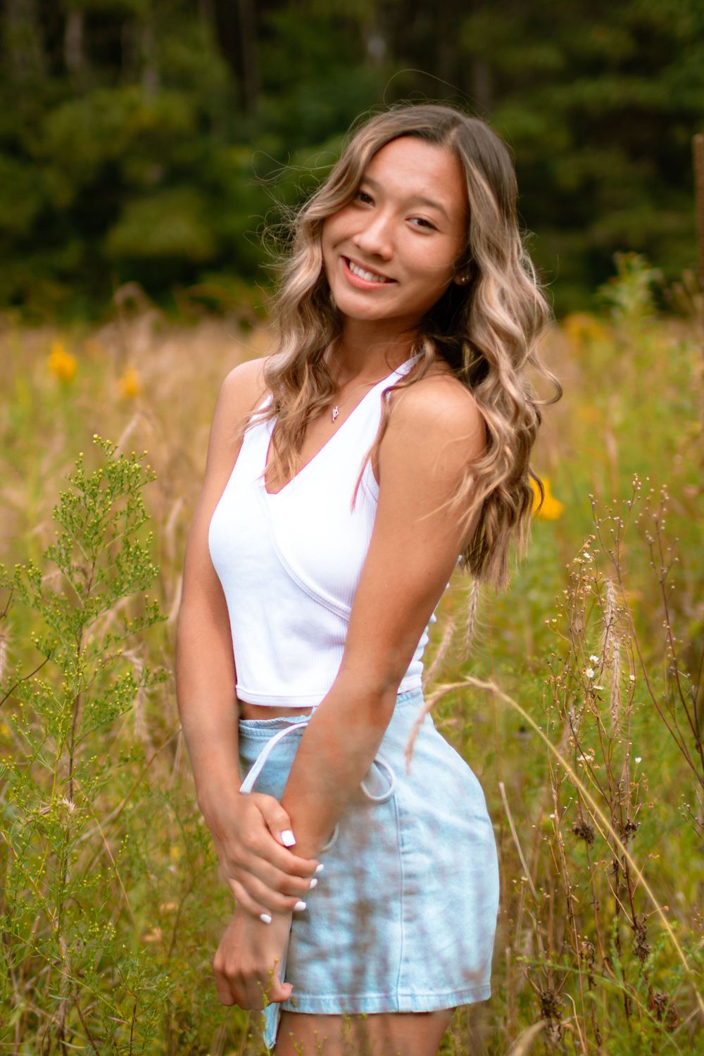 senior girl enjoying sunny tall grass