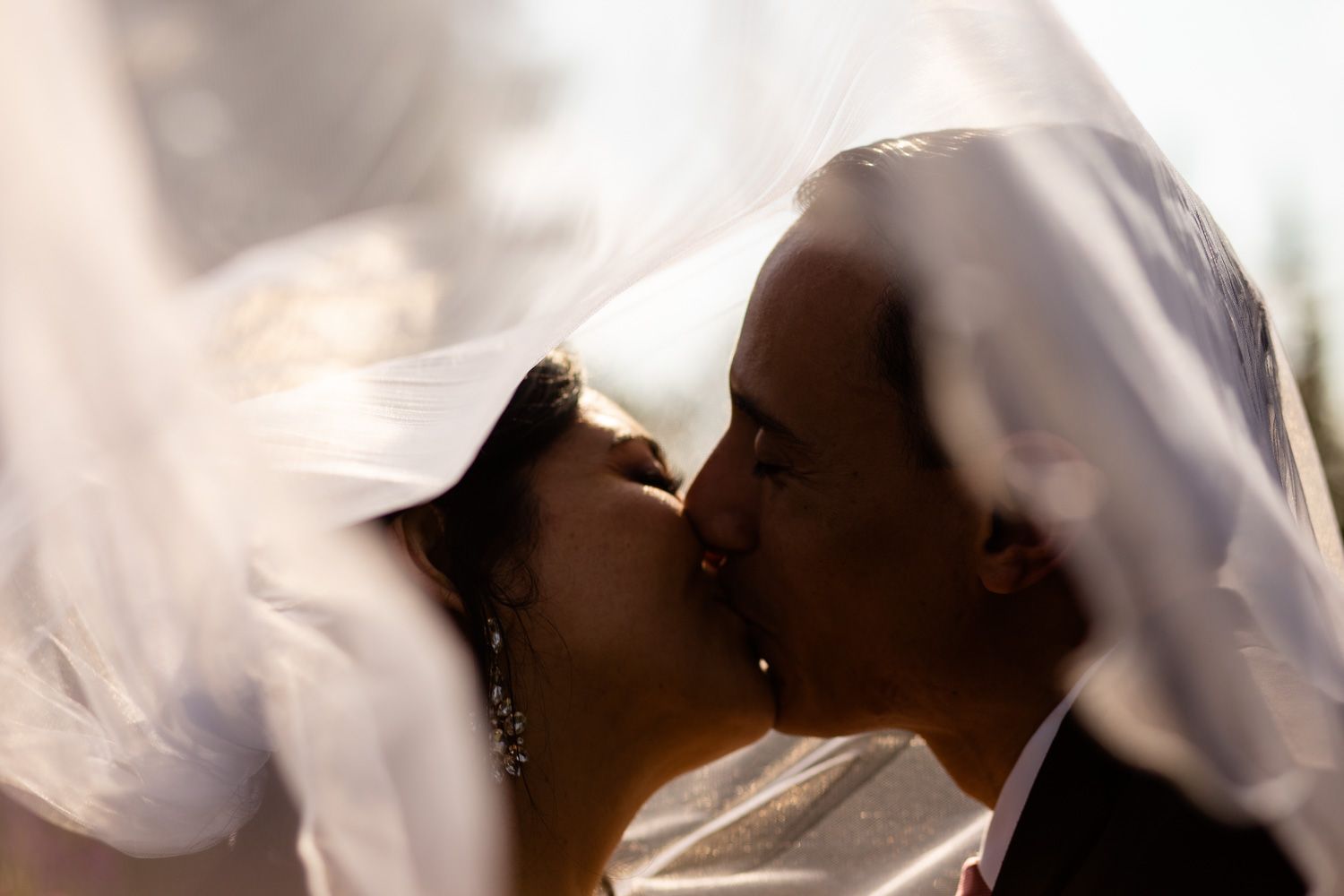 Bride and groom with veil blowing in wind