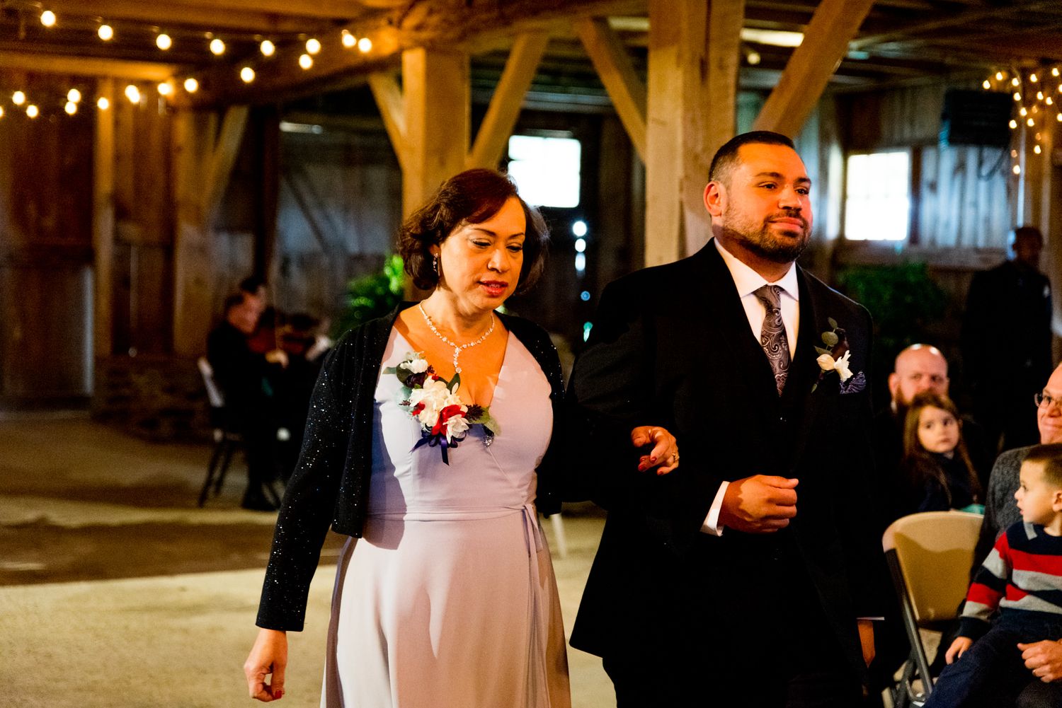 groom and mother of the groom walking down the wedding aisle