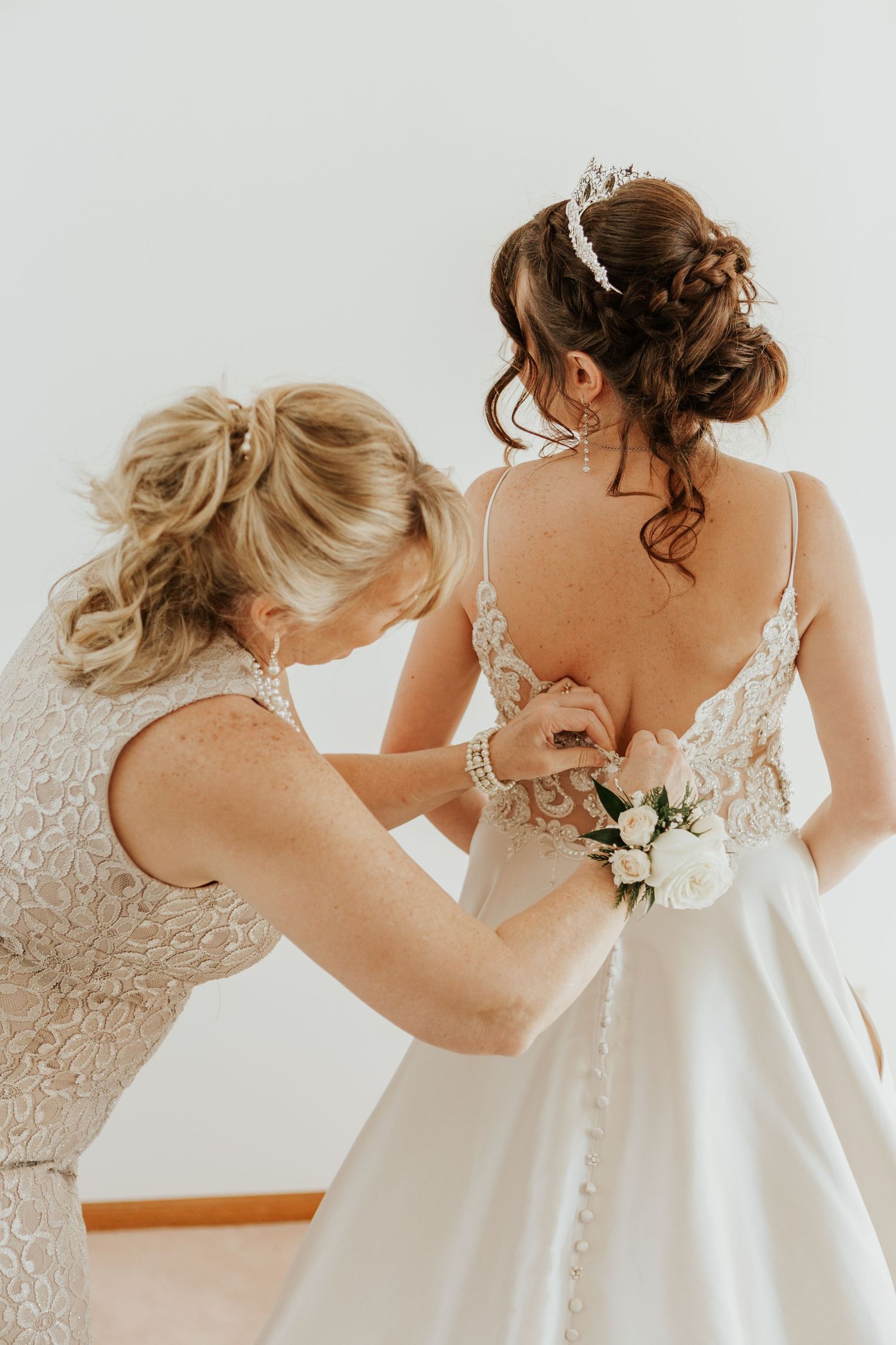 Mother of the bride fixes the brides dress during her Loveland Wedding
