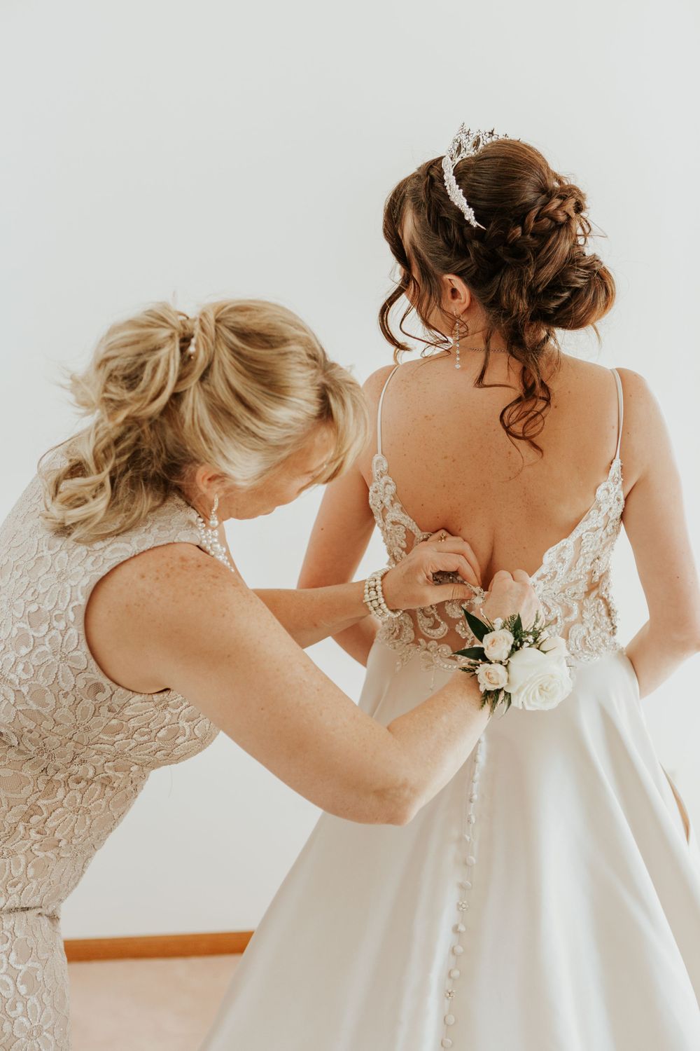 Mother of the bride fixes the brides dress during her Loveland Wedding