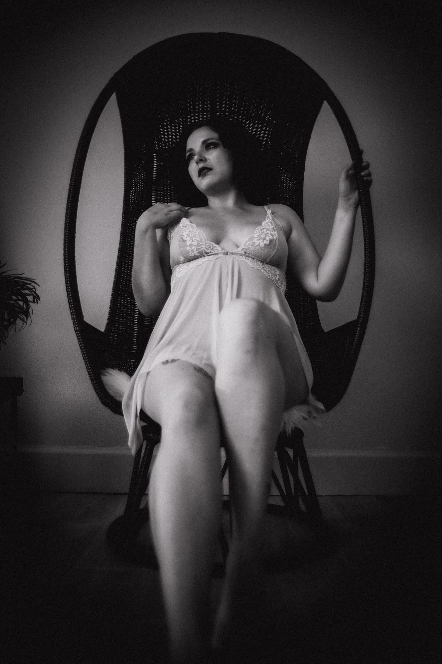 woman in lingerie posing for boudoir photos in wicker egg chair