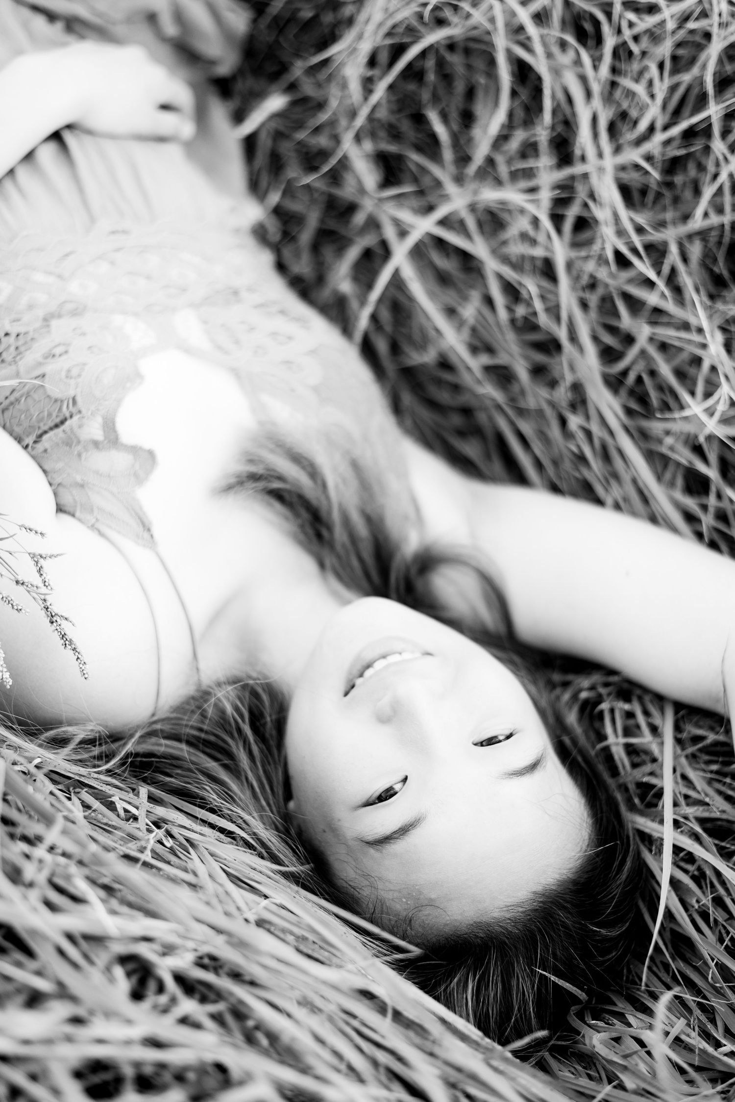 young woman smiling and laying in grass