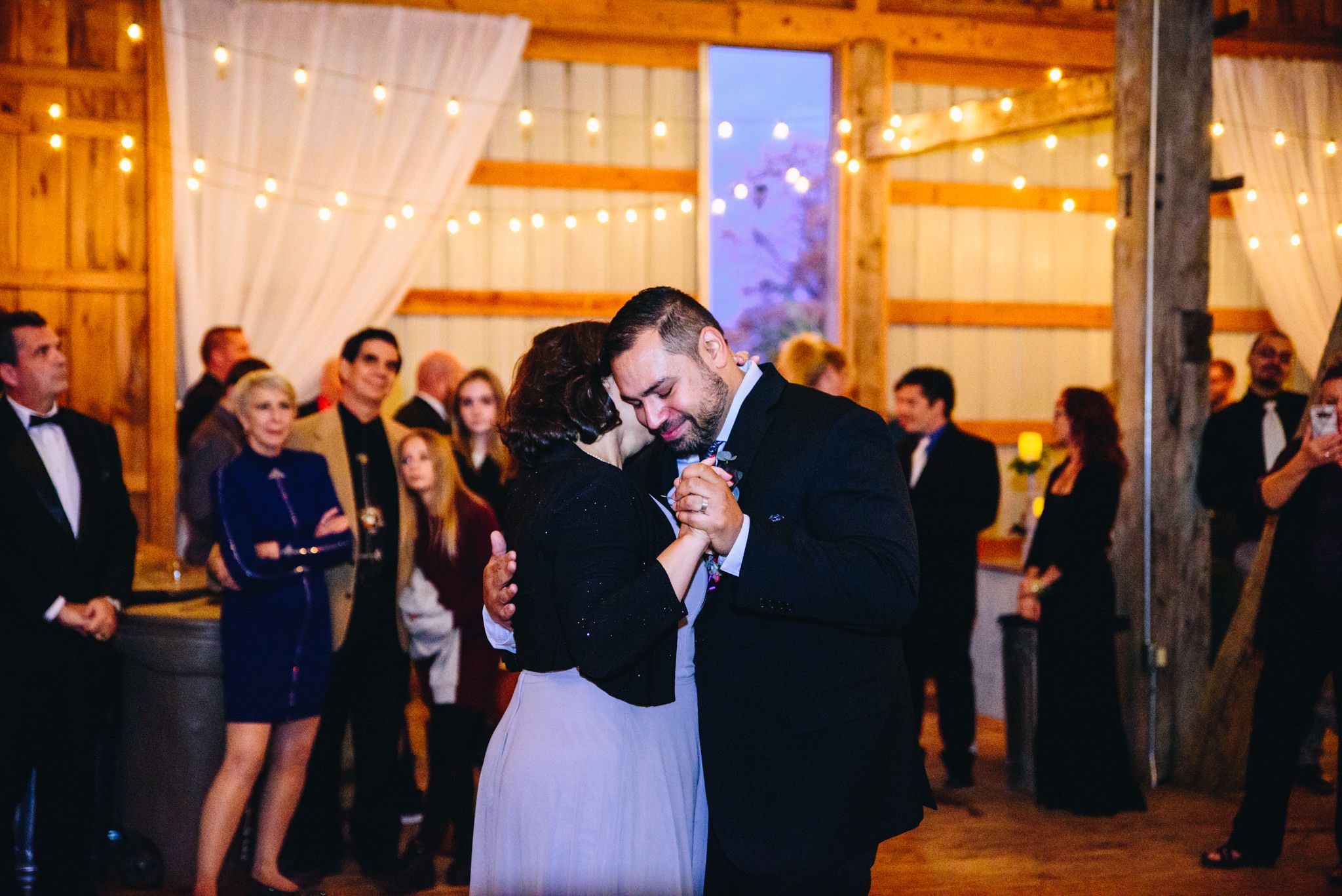 groom dancing with his mother at his wedding with eyes closed leaning on his mom
