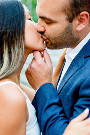 man pulling fiance in by chin, kissing her in streets of Flatiron District