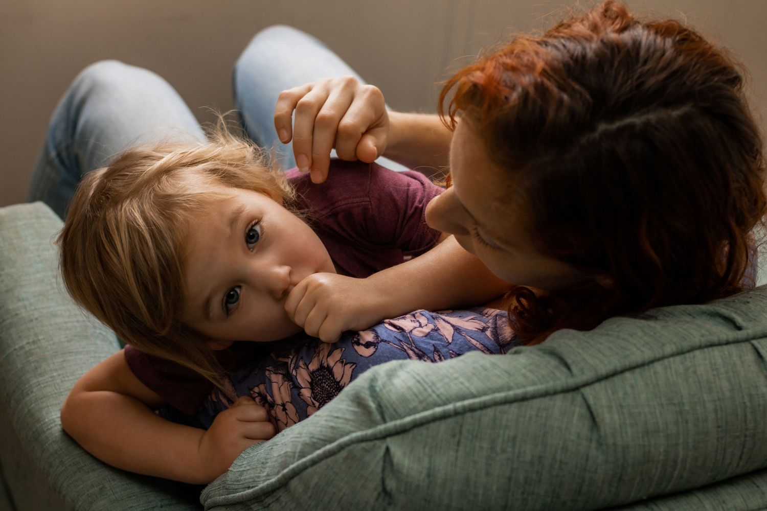 Toddler on moms shoulder in blue chair