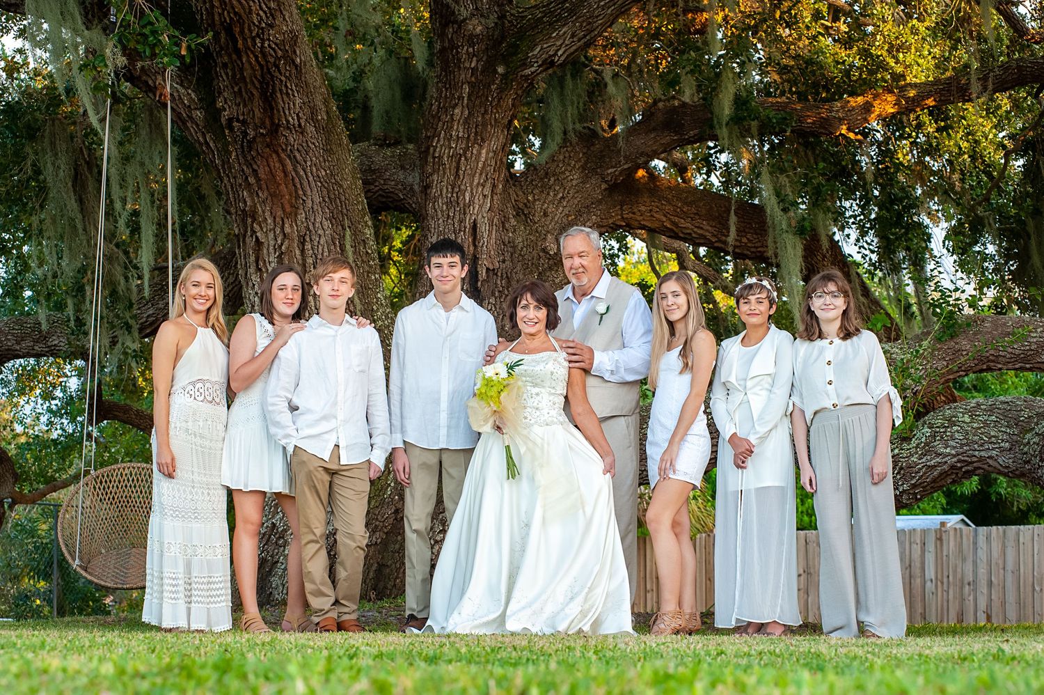 Elder couple pose with seven grandkids at vow renewal ceremony