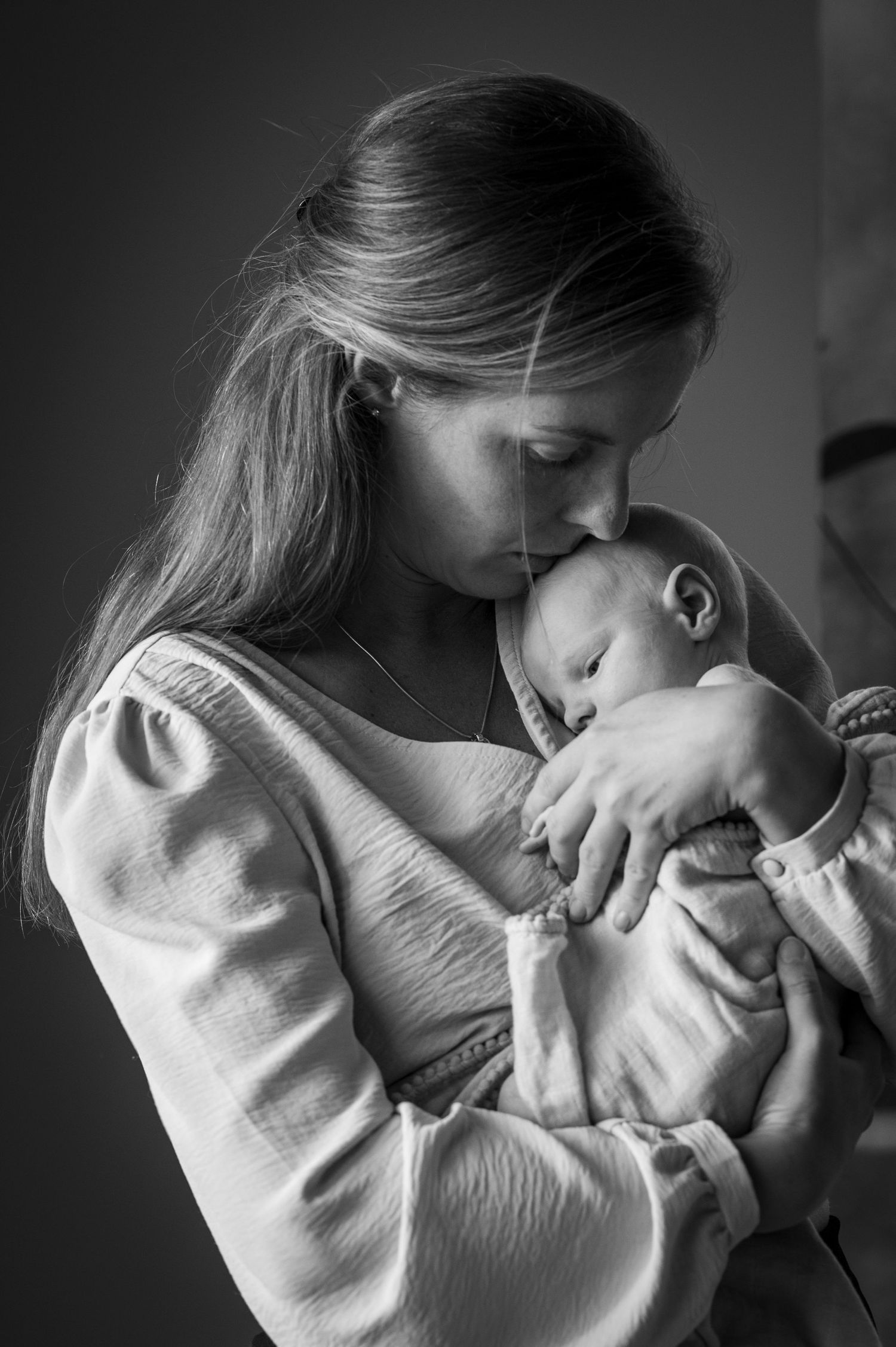 Nyfödd fotografering i hemmiljö av mamma och son