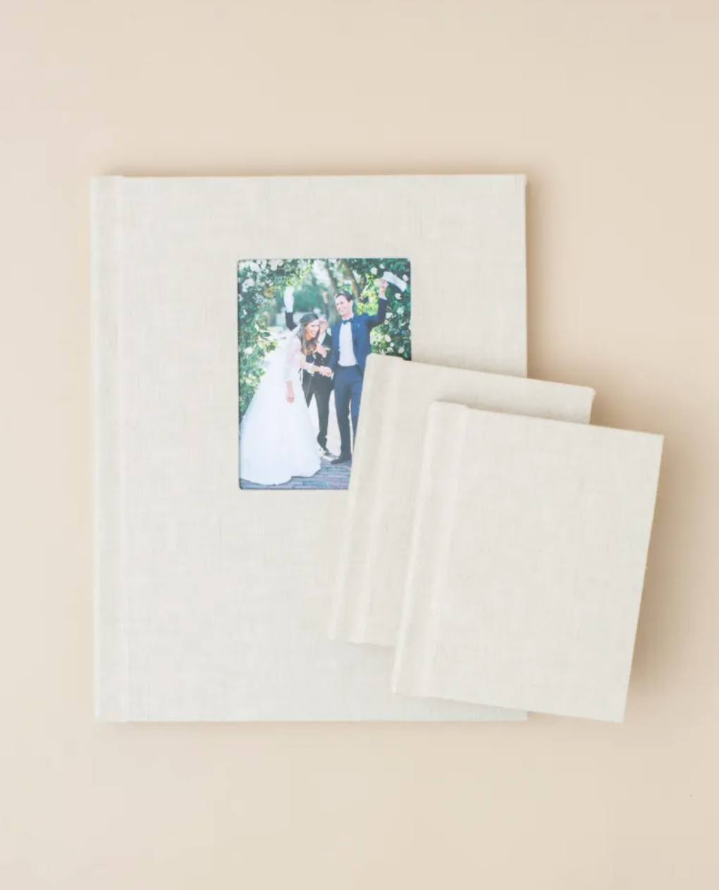 Elegant white wedding album with photo window and matching companion books.