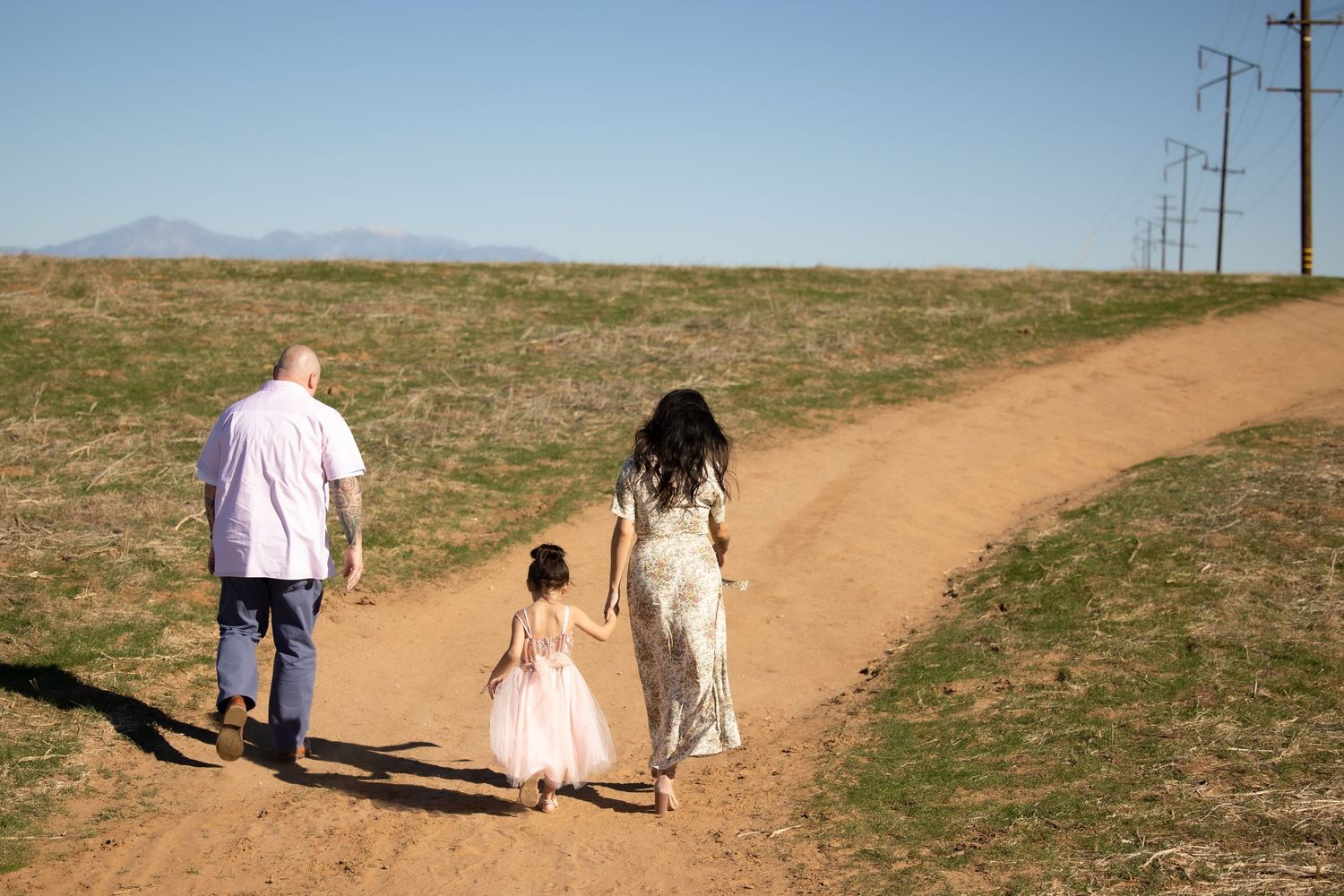 family of three walking on a dirt path