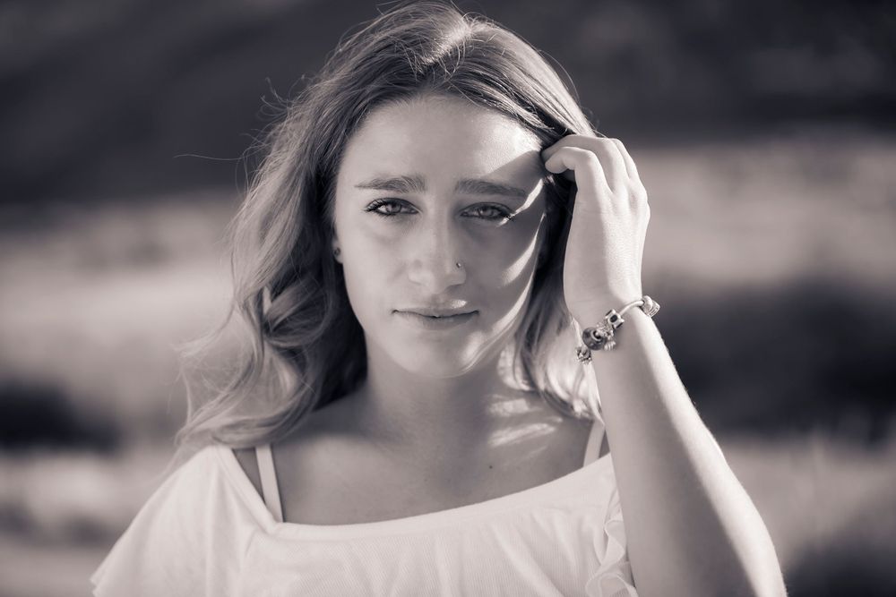 Senior portrait of a girl running fingers through her hair