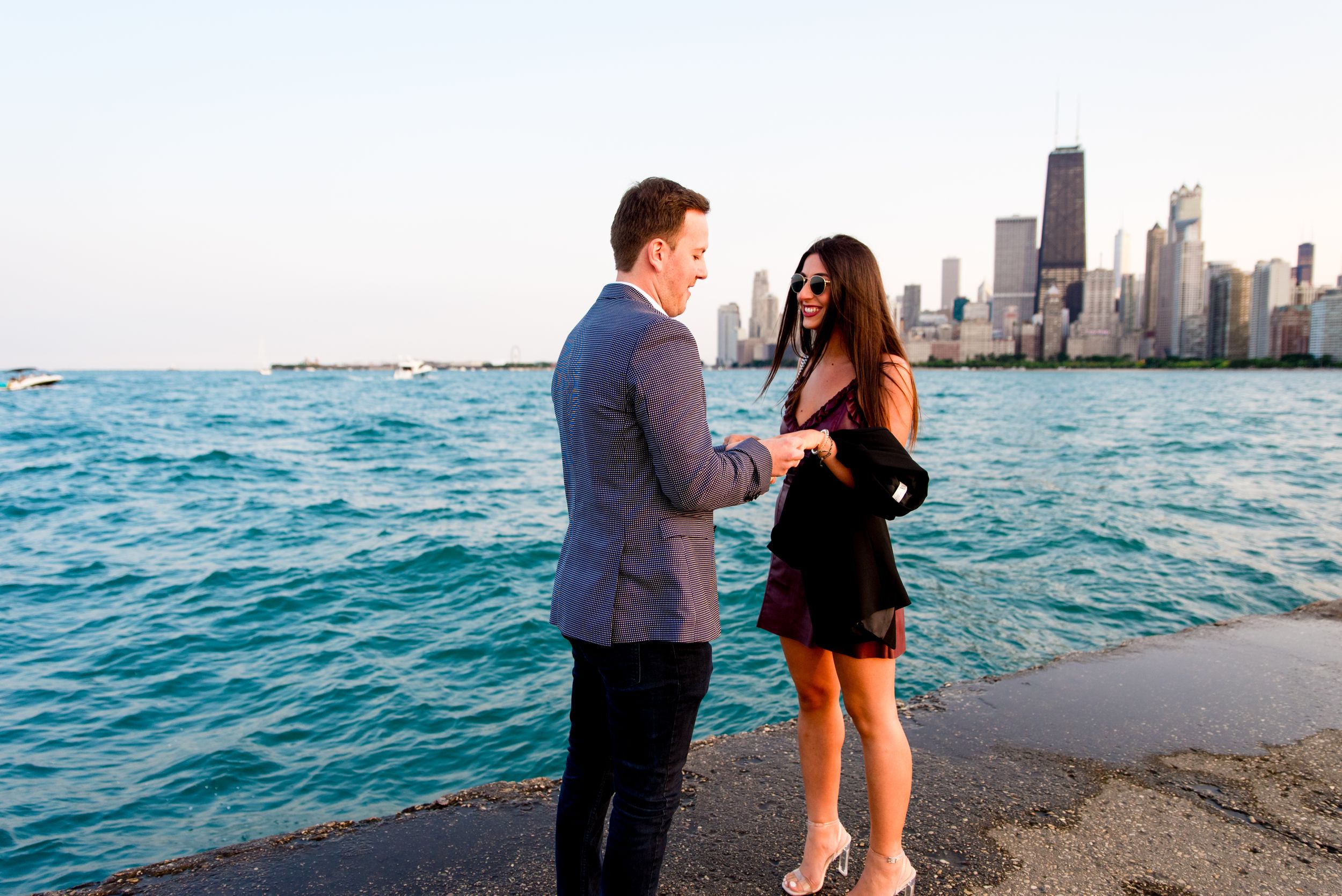 young woman smiling at fiance in front of Chicago skyline after North Avenue Beach proposal