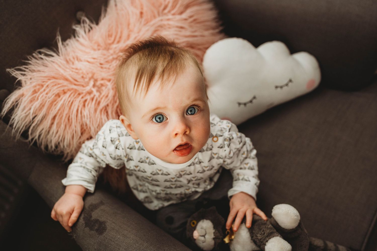 little baby girl sitting in armchair looking up