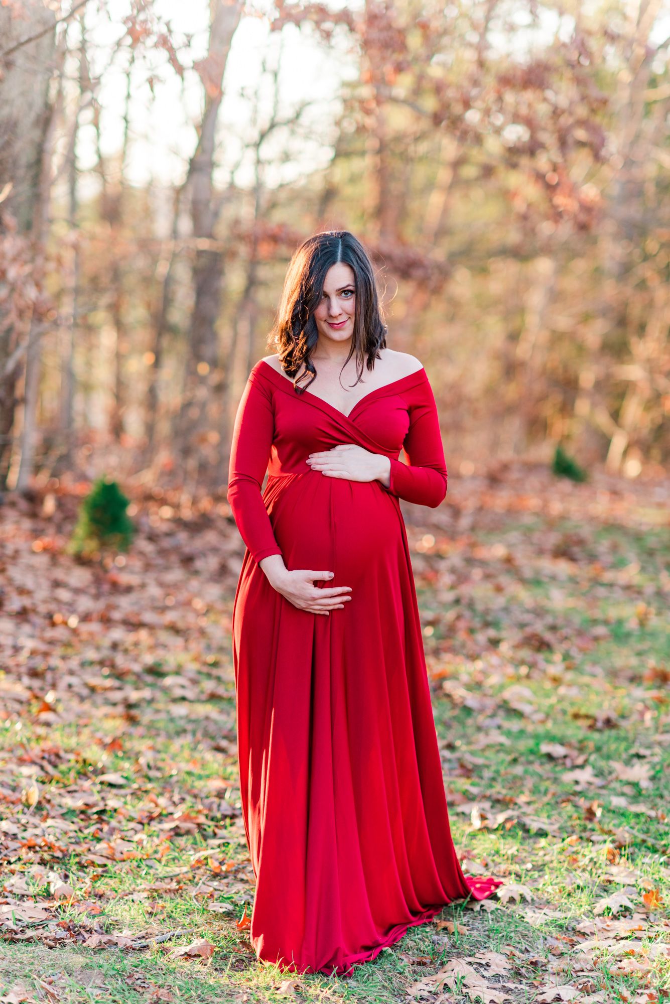 Red maternity dress in winter with golden hour sunlight in Pittsburgh, Pennsylvania