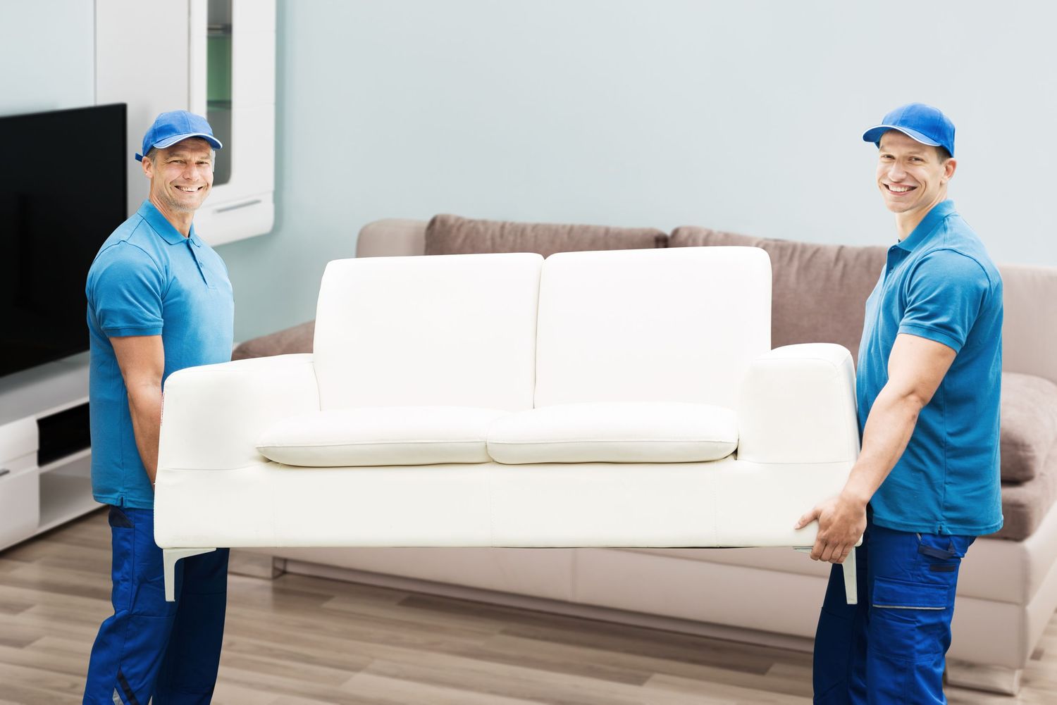 two men moving a couch for simply staging