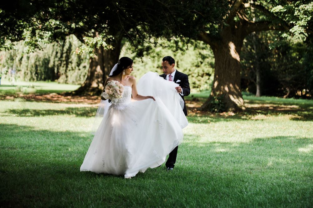 Groom helping bride with her train at Skylands Manor