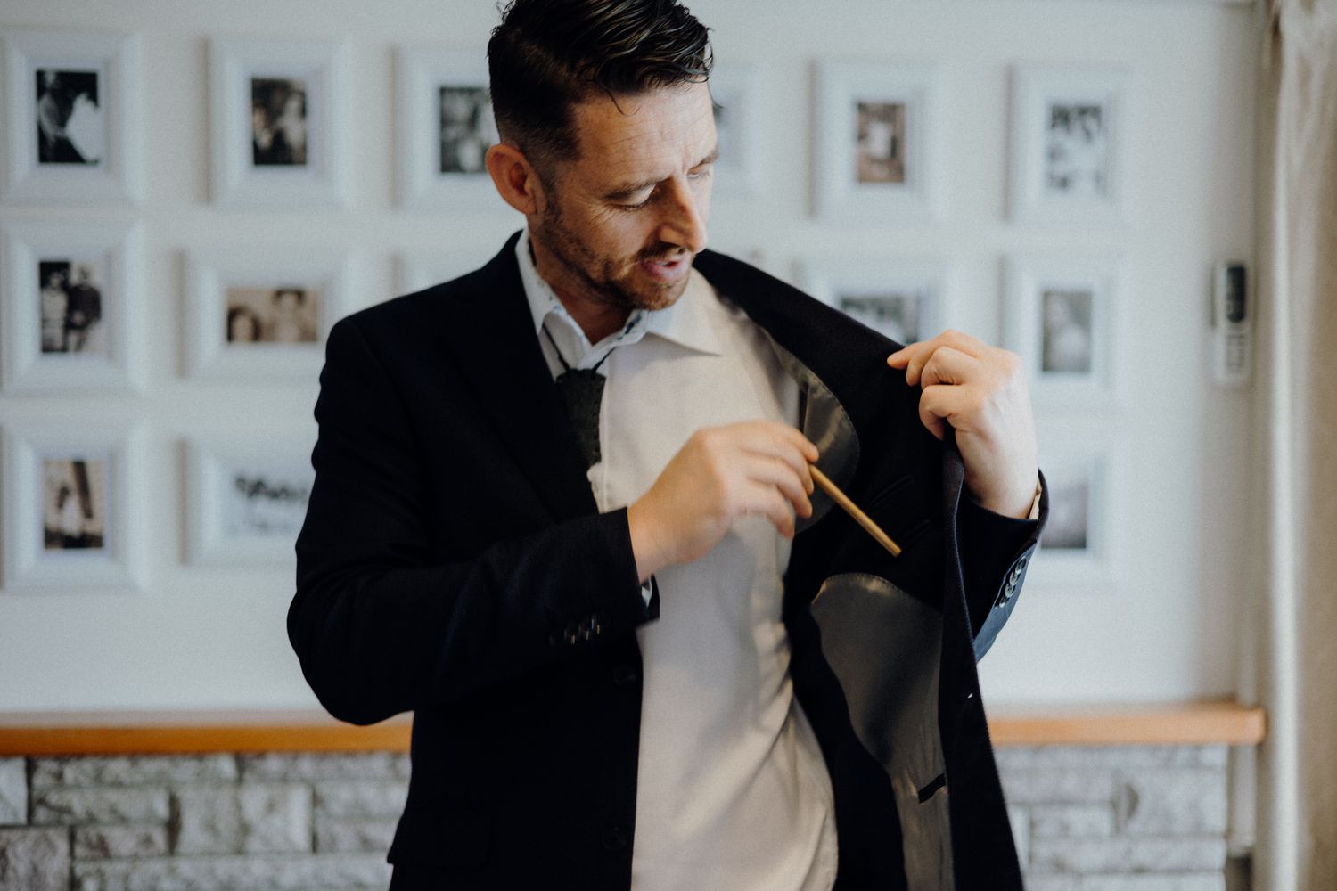 Joyful getting ready moment showing final suit jacket adjustments.