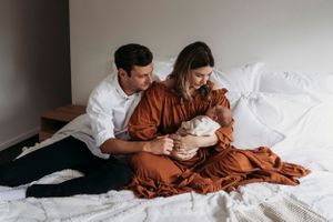 natural newborn baby with new parents in home