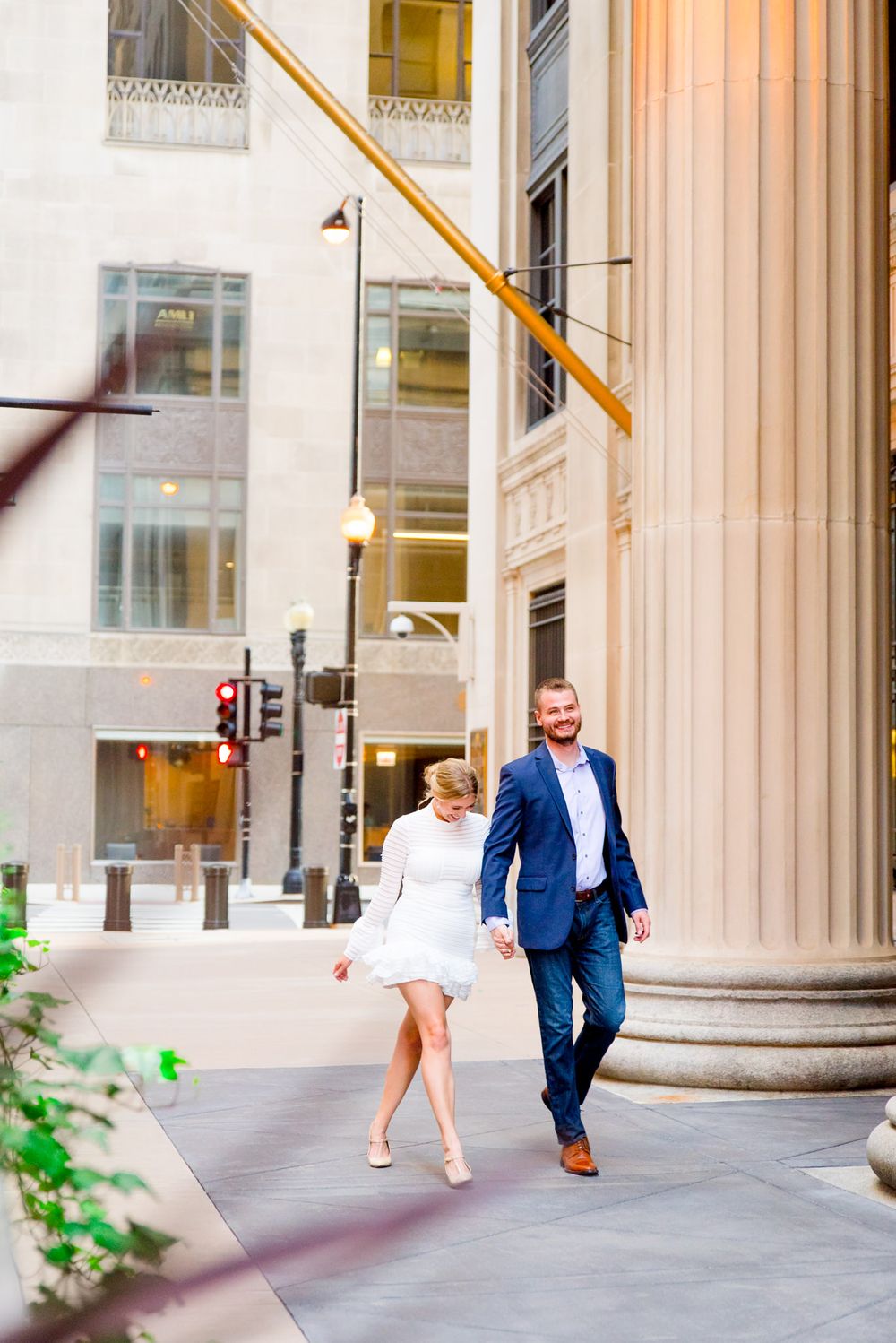 man and woman walking at sunset near Board of Trade Chicago engagement
