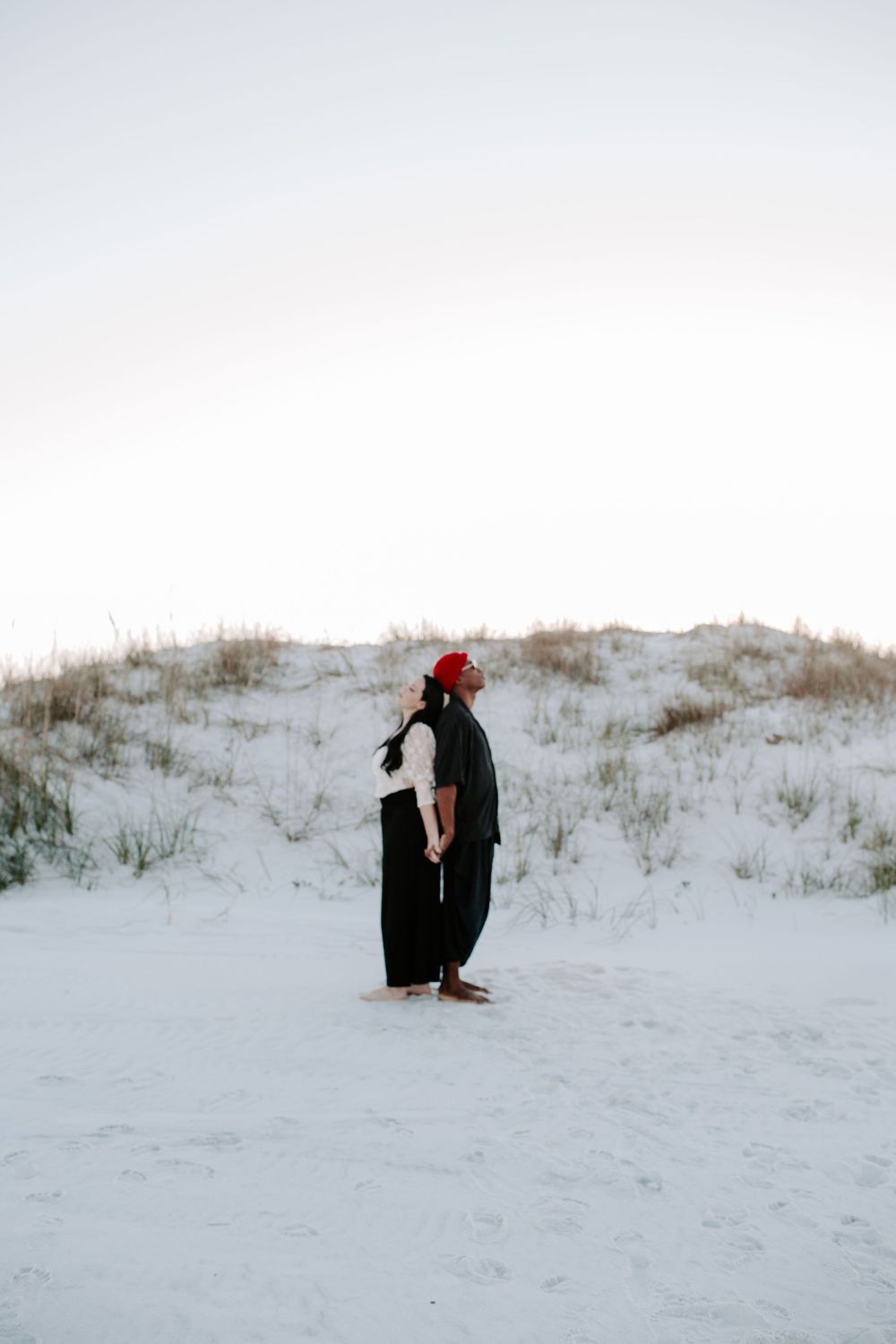 couple standing back to back on the beach during their North Florida couples session