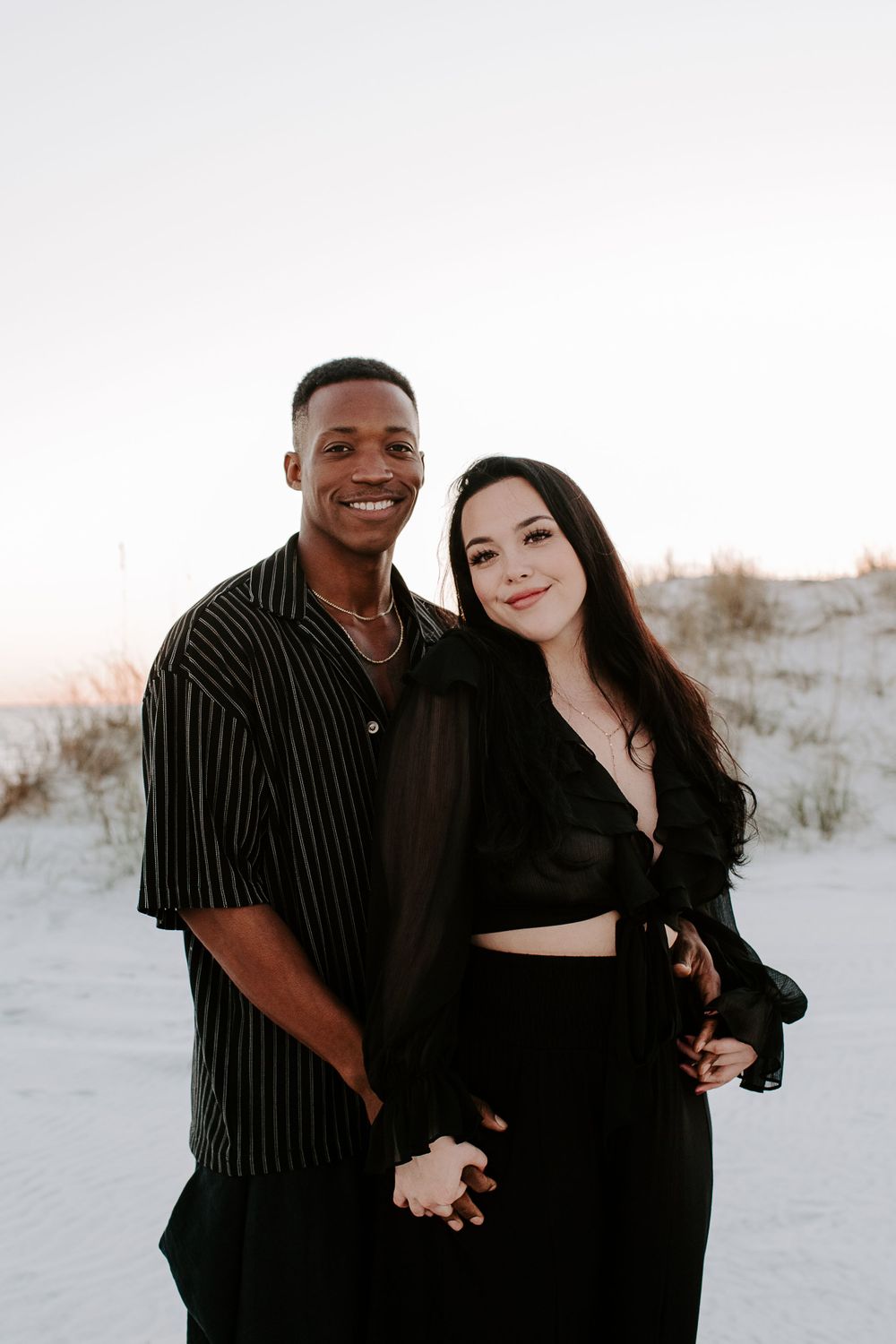 couple smiling and holding hands during a Florida sunset