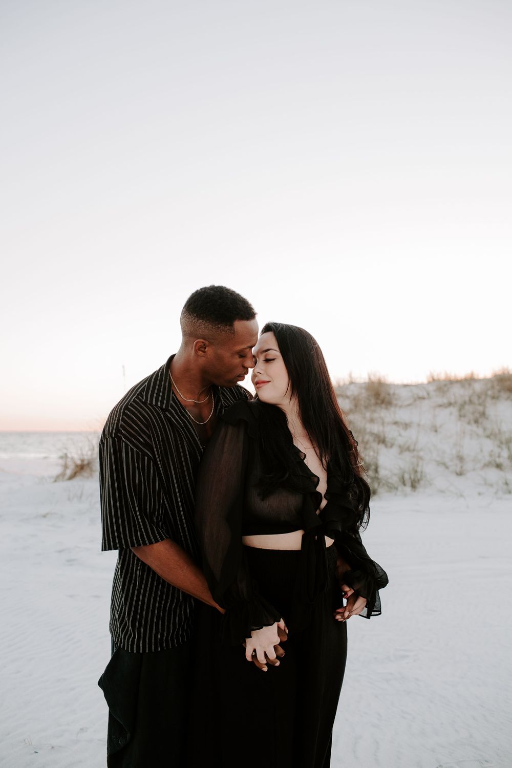 man and woman about to kiss on the beach during sunset