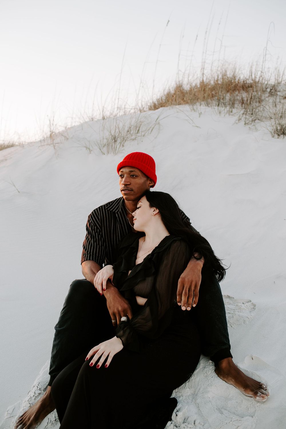 couple sitting near sand dunes in Destin Florida during their beach session