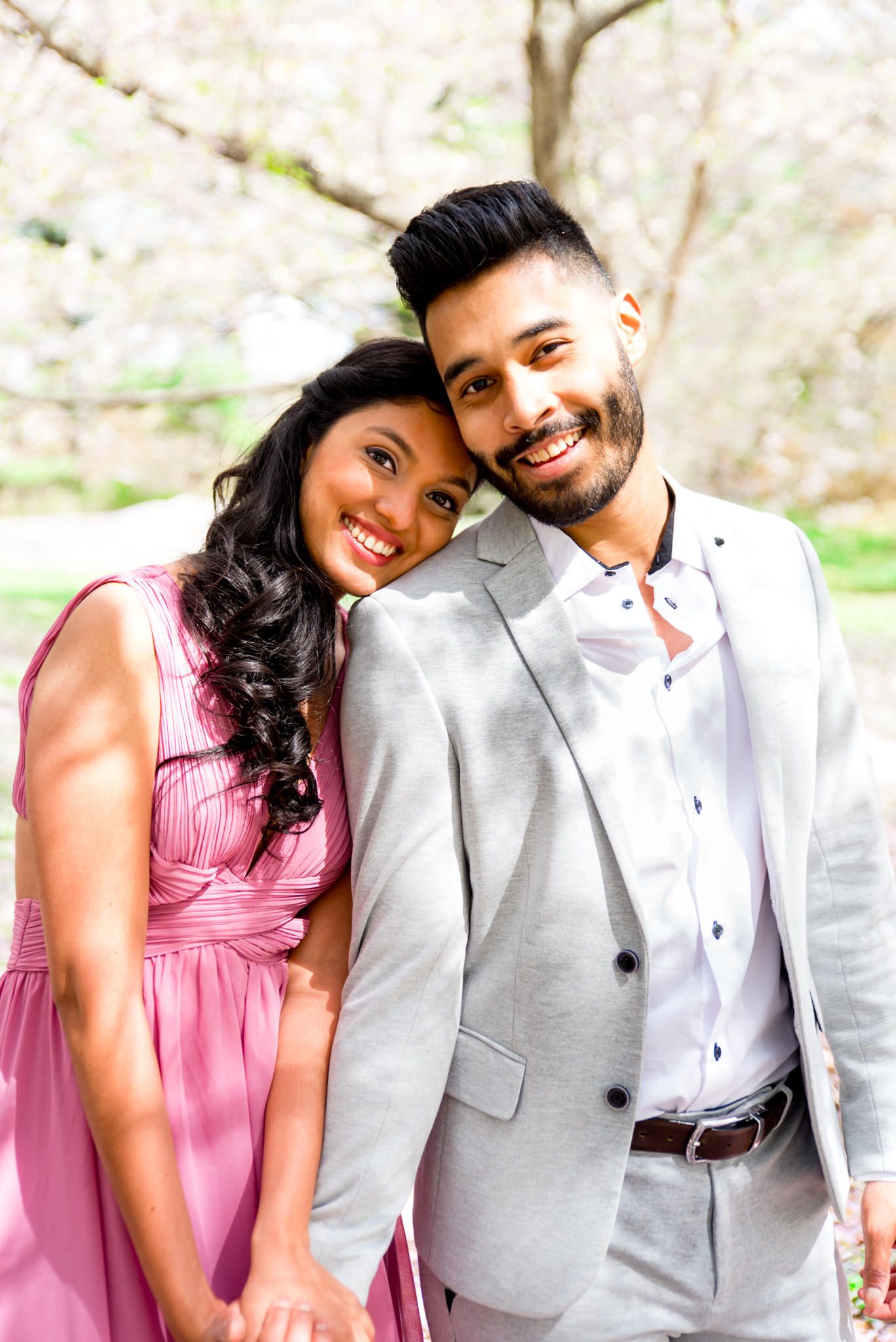 young couple holding hands under the cherry blossoms in Central Park engagement photos
