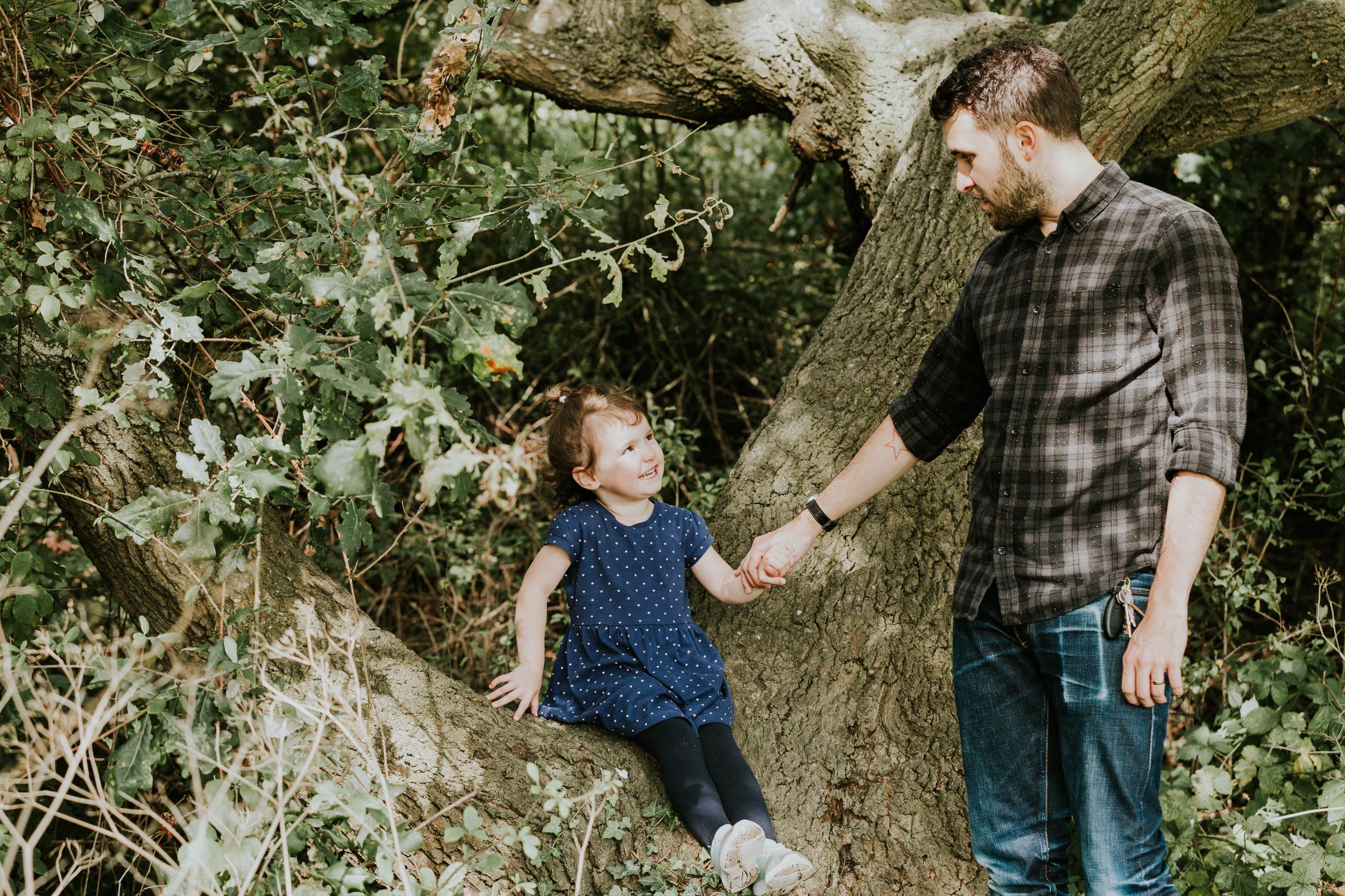 dad and daughter in forest holding hands