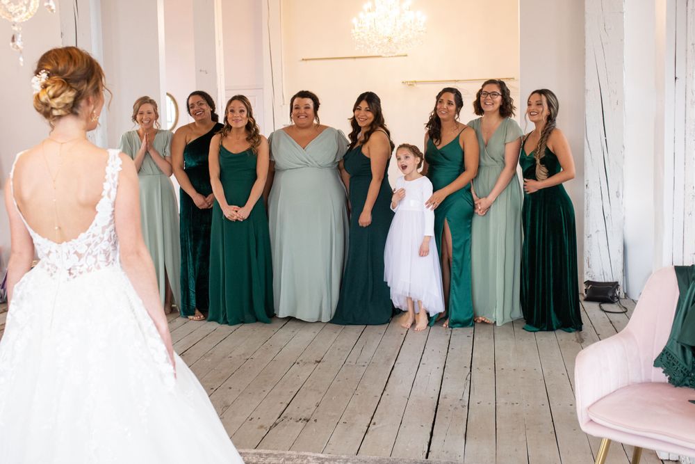 A group of bridesmaids reacting to their first look at the bride at the Northern Pacific Center in Central, MN