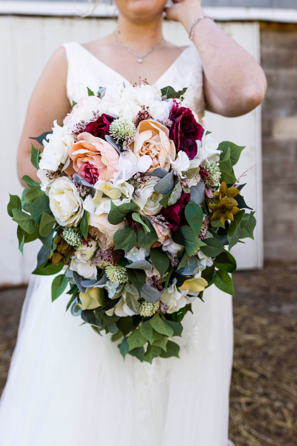 A close up of a bride holding her bouquet before walking down the aisle at Northern Pacific Center in Brainerd, MN