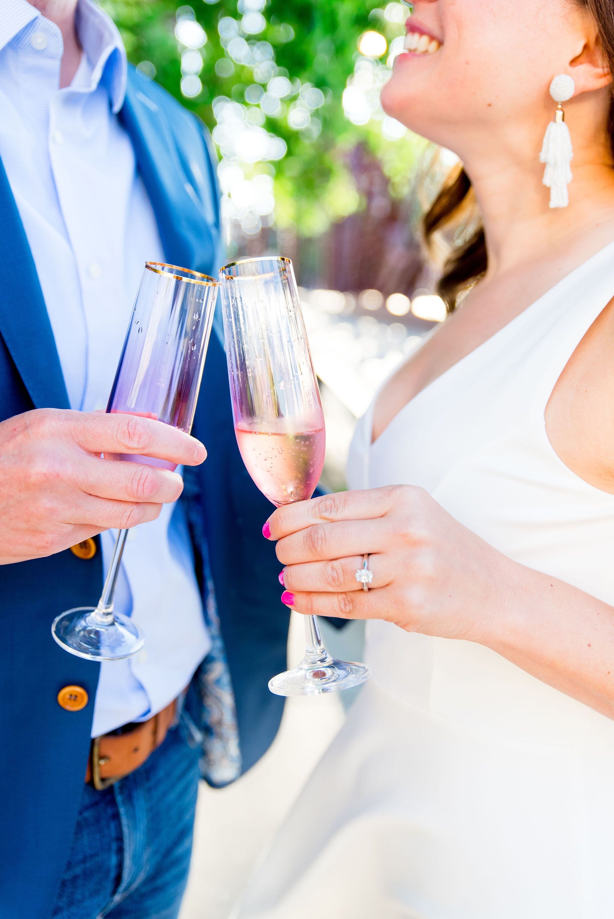 engaged couple clinking pink and gold champagne glasses from anthropologie at Kinzie St Bridge engagement pictures