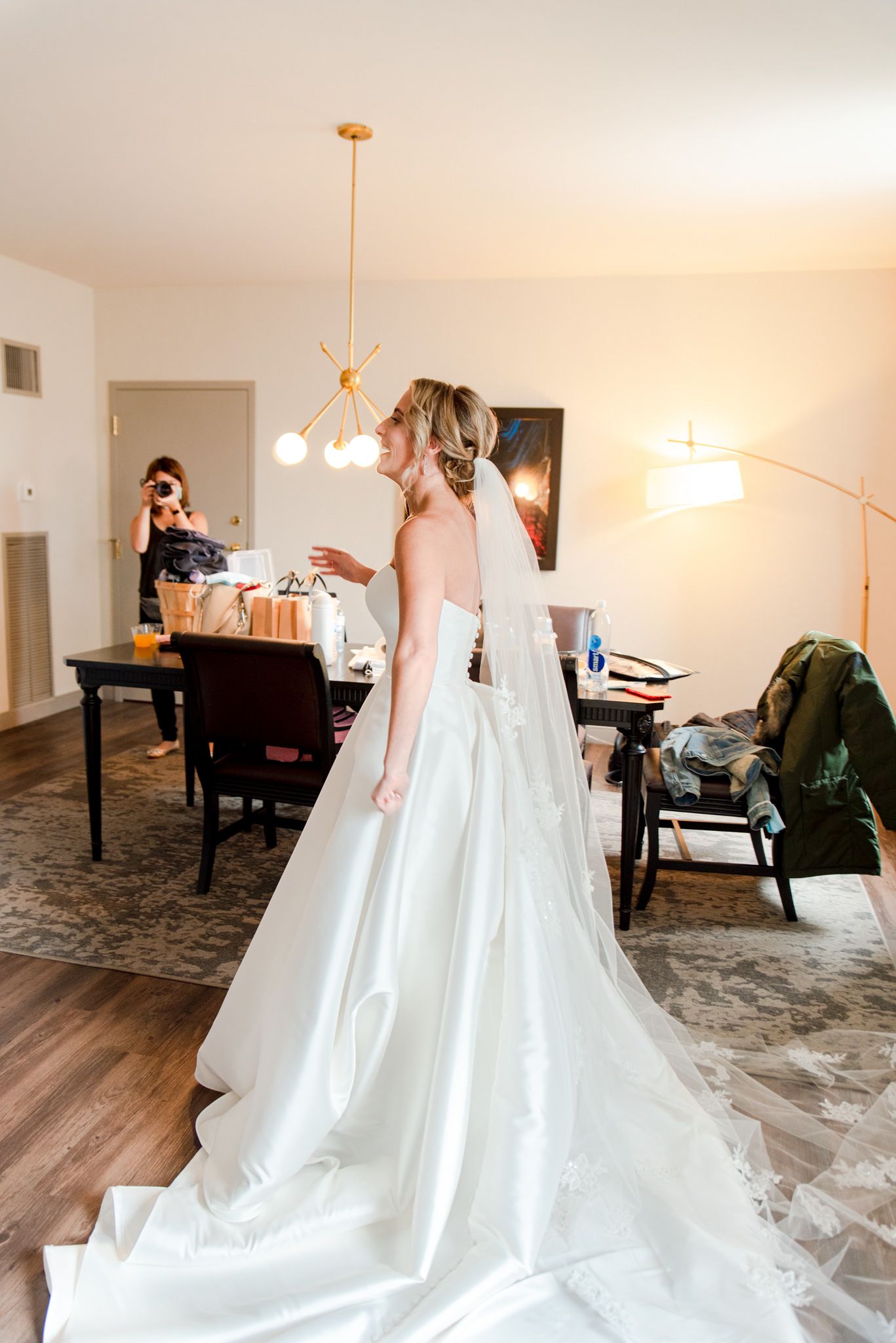 blonde bride in long veil and wedding dress smiling at her bridesmaids after they do a bridesmaids first look