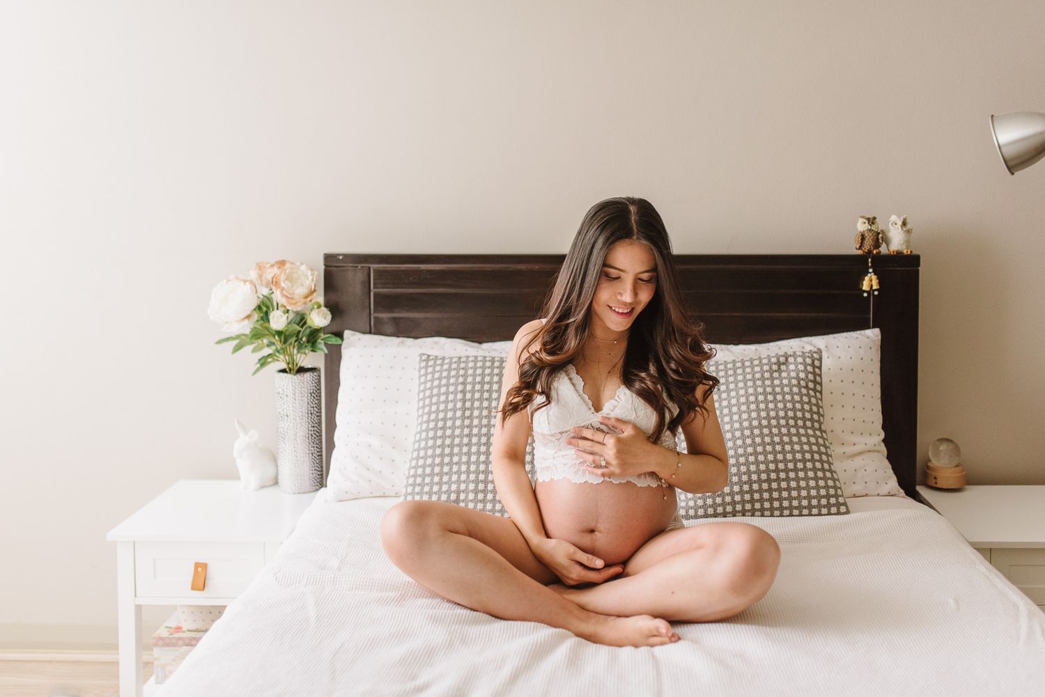 pregnant woman sitting on her bed