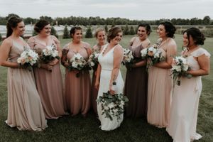 Finger lakes bride showing off her dress to her bridesmaids at Climbing Bines