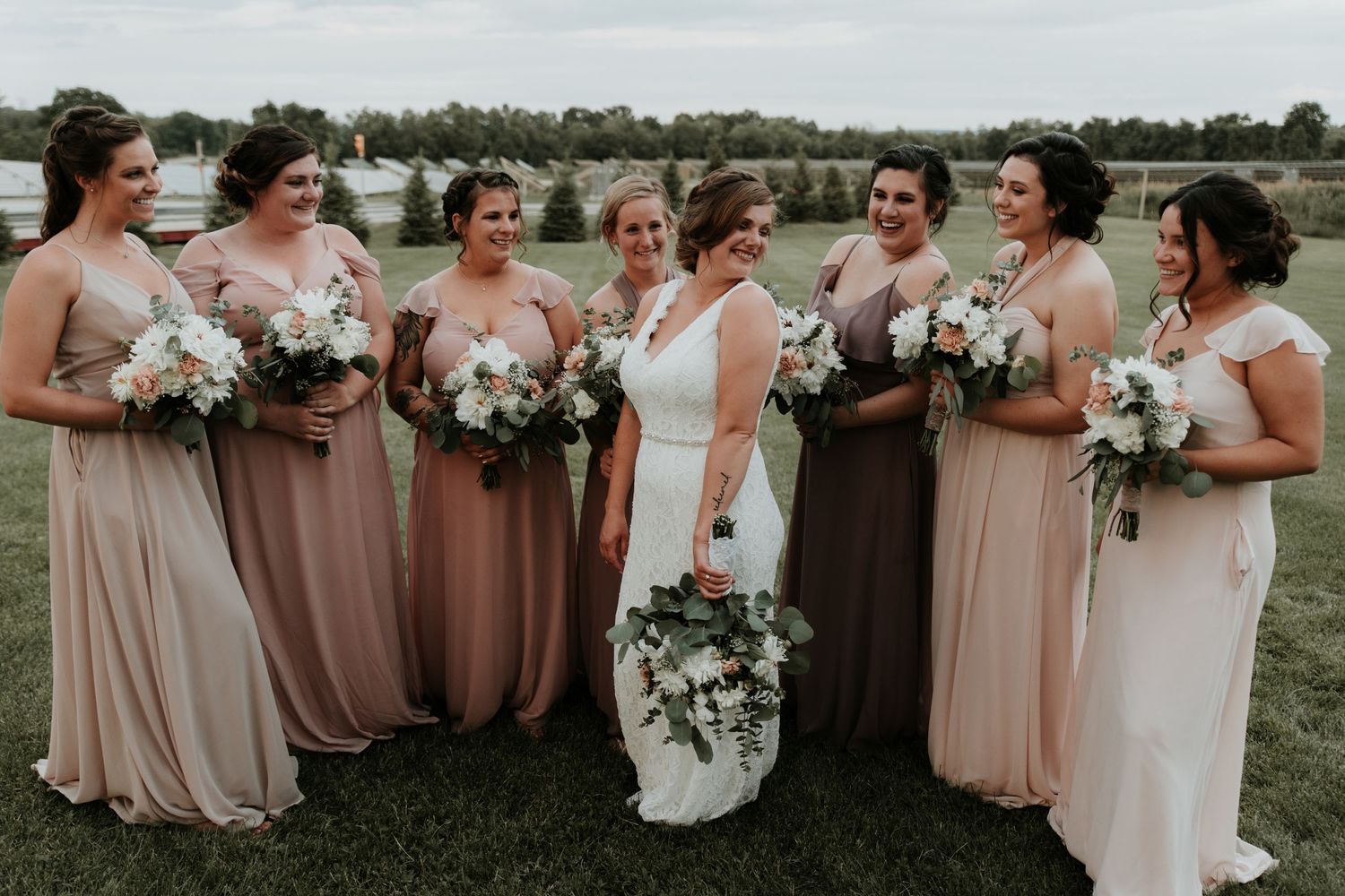 Finger lakes bride showing off her dress to her bridesmaids at Climbing Bines