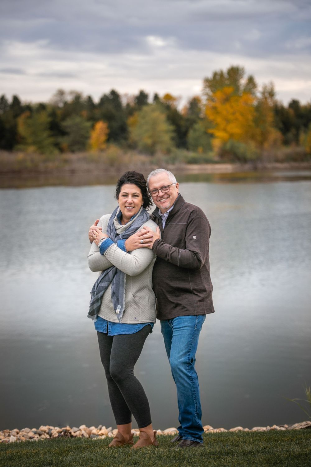 anniversary couple holding each other near water in September