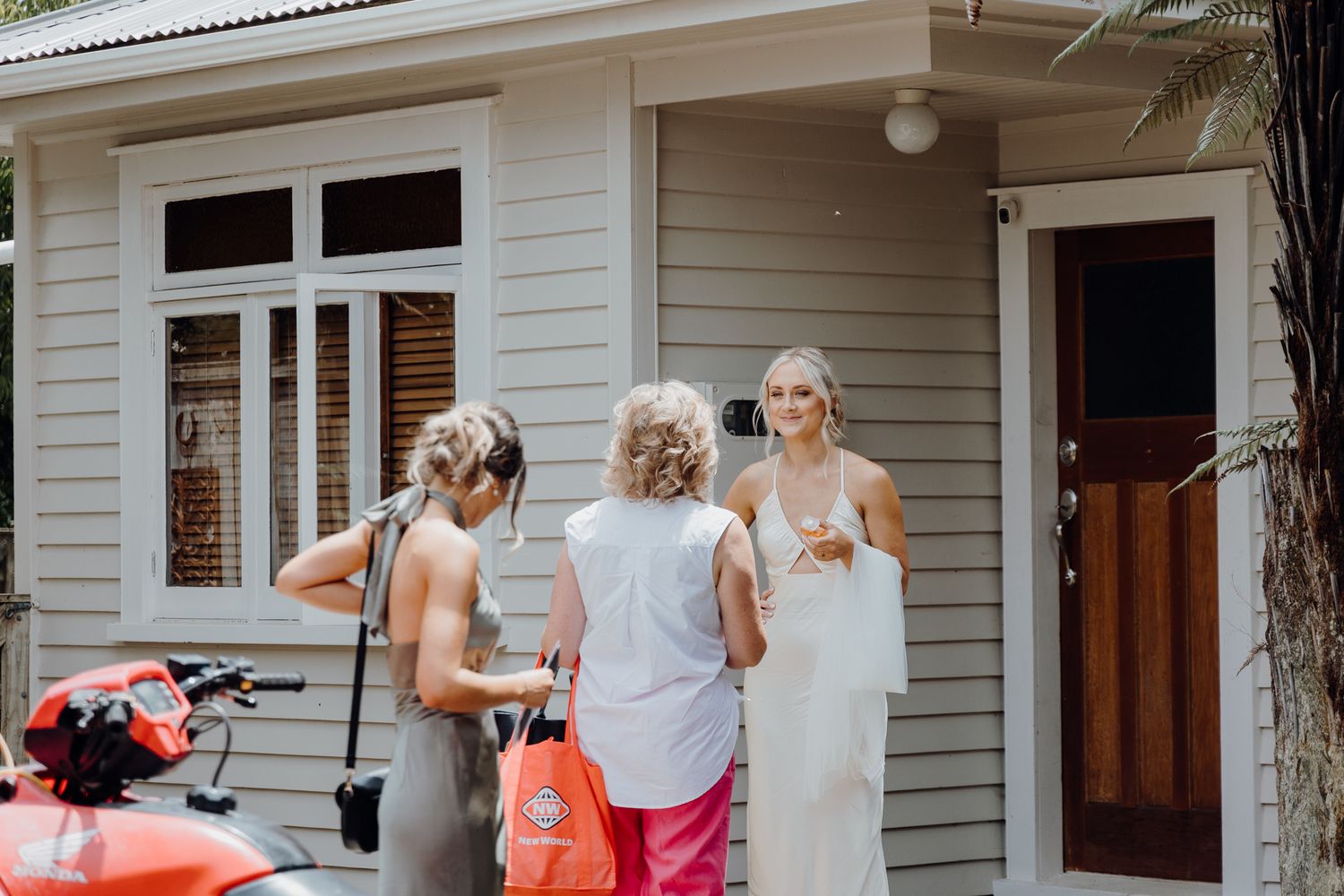 Wedding preparations taking place on the porch of a white craftsman style house with an orange ATV visible.