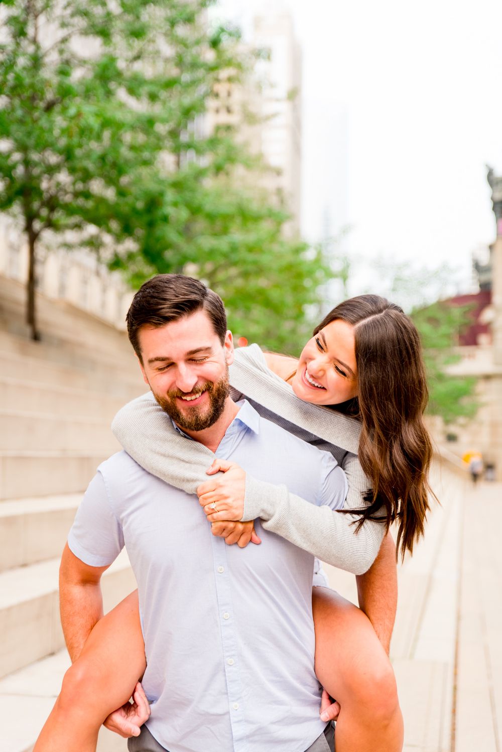 woman with brown hair laughing with fiance at Chicago Riverwalk sunrise engagement pictures
