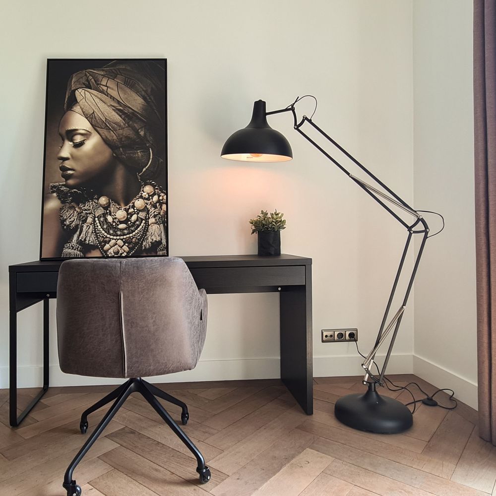 strakke stijlvolle kantoorinrichting thuiswerkplek met grote bureaulamp en wanddecoratier