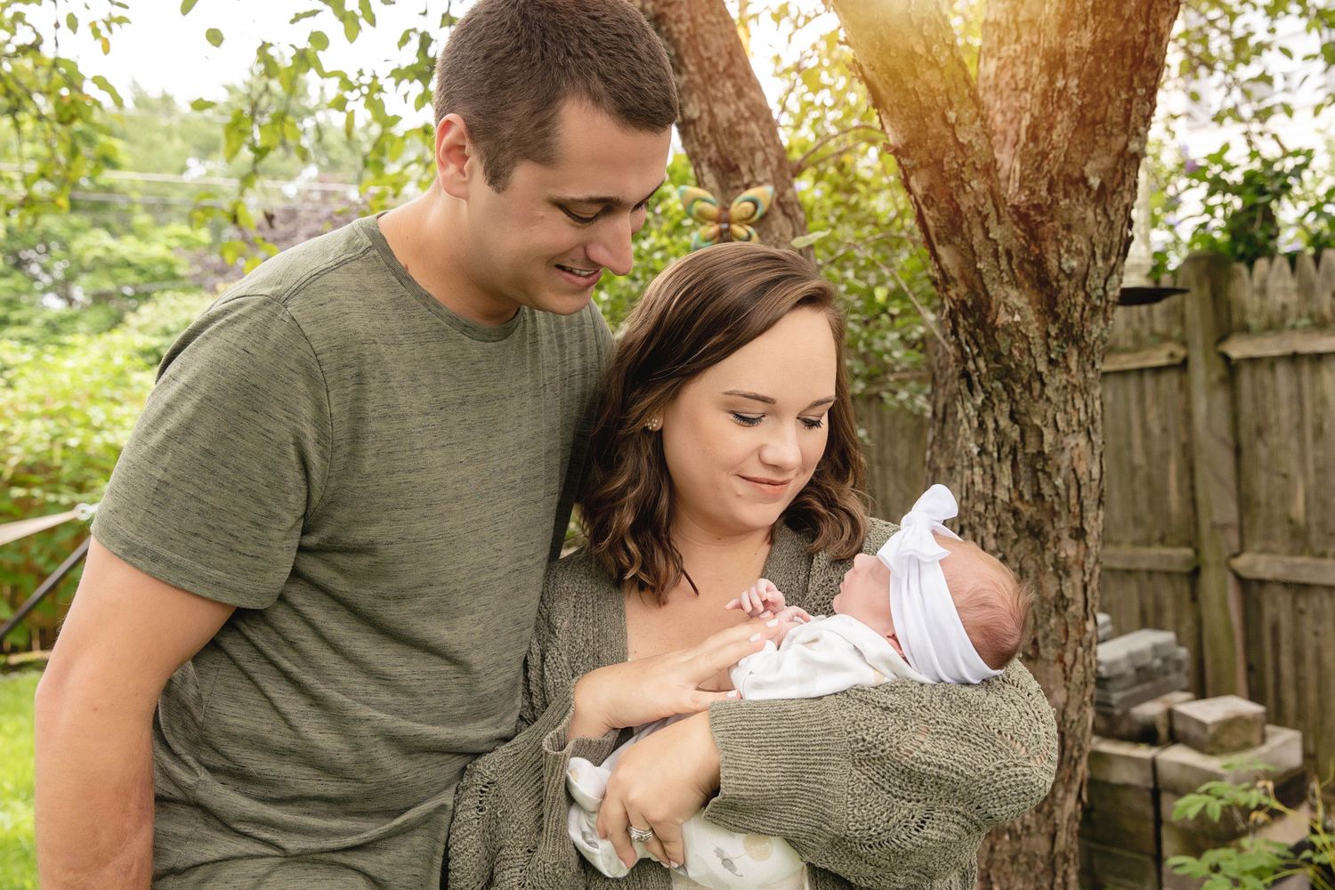 A family shares a tender moment together in their backyard during sunset.