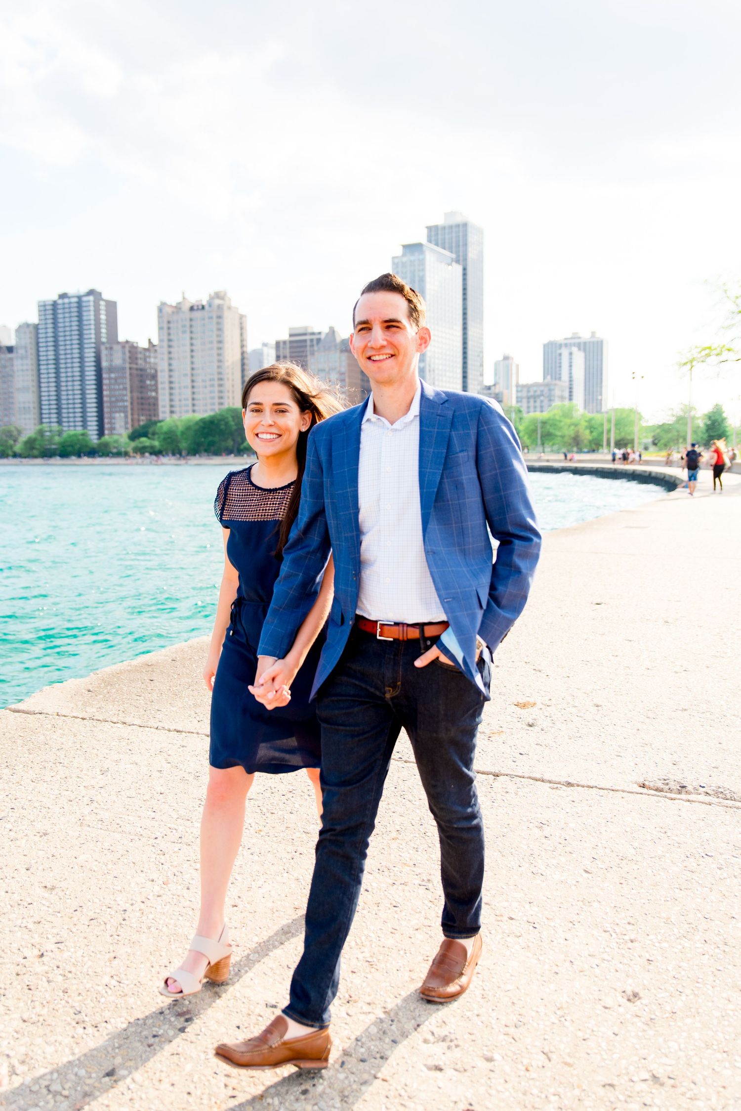 man and woman walking along pier at North Avenue Beach after proposal in Chicago